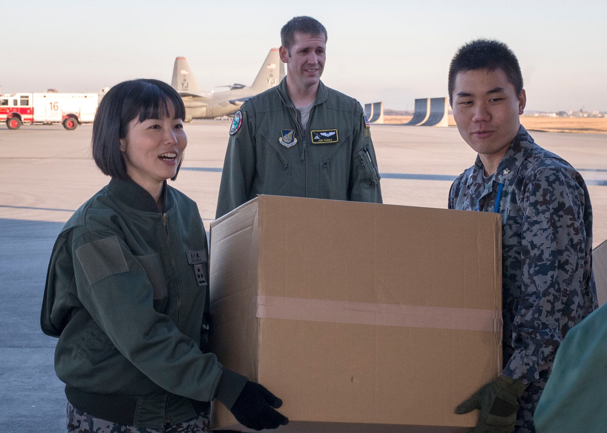 Japanese Airmen carry a box of donated goods provided by the Japan Air Self Defense Force aboard a U.S. C-130 Hercules at Yokota Air Base, Japan, Dec. 13, 2013. The goods will be dropped over several islands in the Federated States of Micronesia as a part of Operation Christmas Drops. (U.S. Air Force photo by Captain Raymond Geoffroy/Released)
