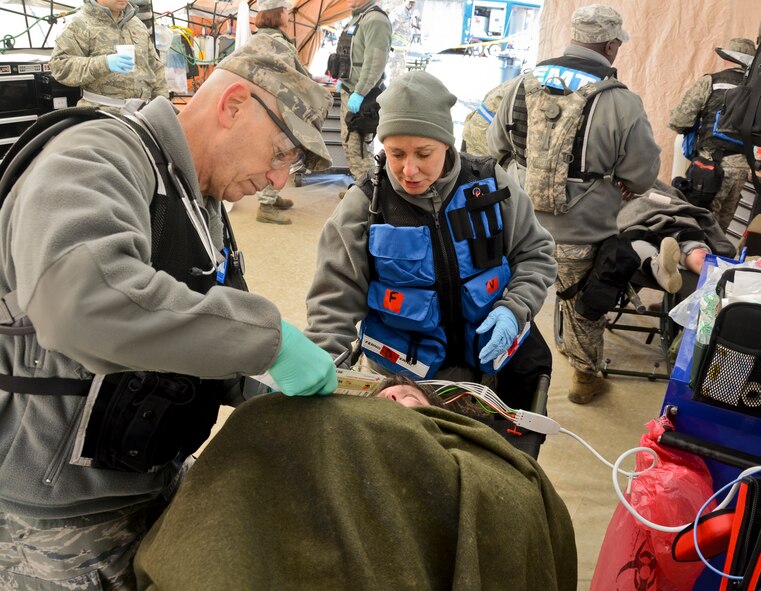 U.S.  Air Force Lt. Col. Jewell Churchman, right, 116th Medical Group, Georgia Air National Guard, comforts a patient with simulated injuries during the Region 4 Homeland Response Force (HRF) external evaluation at Pelham Range, Anniston, Ala., Dec. 12, 2013. The medical group from the 116th Air Control Wing, stationed at Robins Air Force Base, Ga., is a key component of the Region 4 HRF whose mission is to respond during disasters in the Southeast U.S. region. During the evaluation, the task force comprised of Air and Army National Guardsmen, responded to various scenarios that tested their ability to save lives and mitigate suffering in order to ensure their preparedness in the event of an incident or catastrophic event. (U.S. Air National Guard photo by Tech. Sgt. Regina Young/Released)