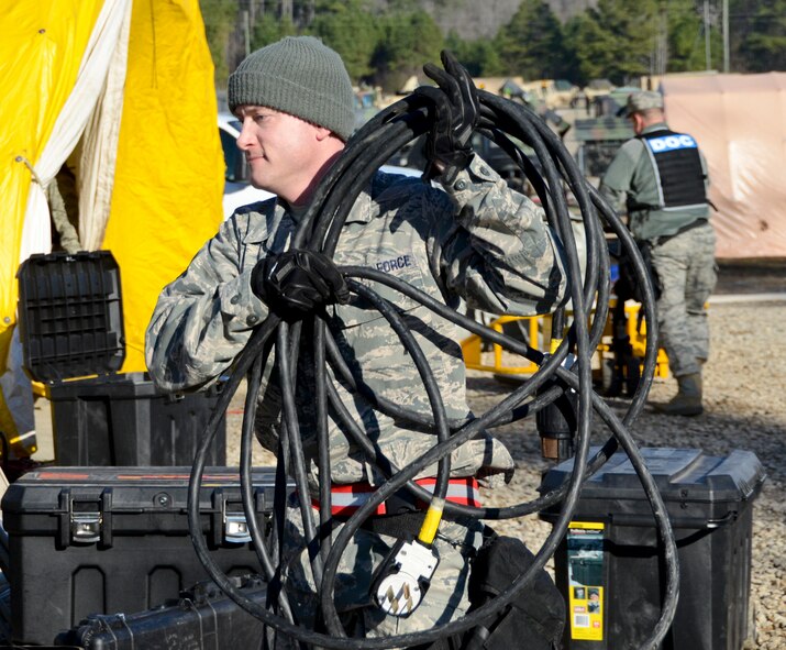 U.S. Air Force James Neesmith, 116th Medical Group, Georgia Air National Guard, carries equipment to assist in preparing medical tents during the Region 4 Homeland Response Force (HRF) external evaluation at Pelham Range, Anniston, Ala., Dec. 12, 2013. The medical group from the 116th Air Control Wing, stationed at Robins Air Force Base, Ga., is a key component of the Region 4 HRF whose mission is to respond during disasters in the Southeast U.S. region. During the evaluation, the task force comprised of Air and Army National Guardsmen, responded to various scenarios that tested their ability to save lives and mitigate suffering in order to ensure their preparedness in the event of an incident or catastrophic event. (U.S. Air National Guard photo by Tech. Sgt. Regina Young/Released)