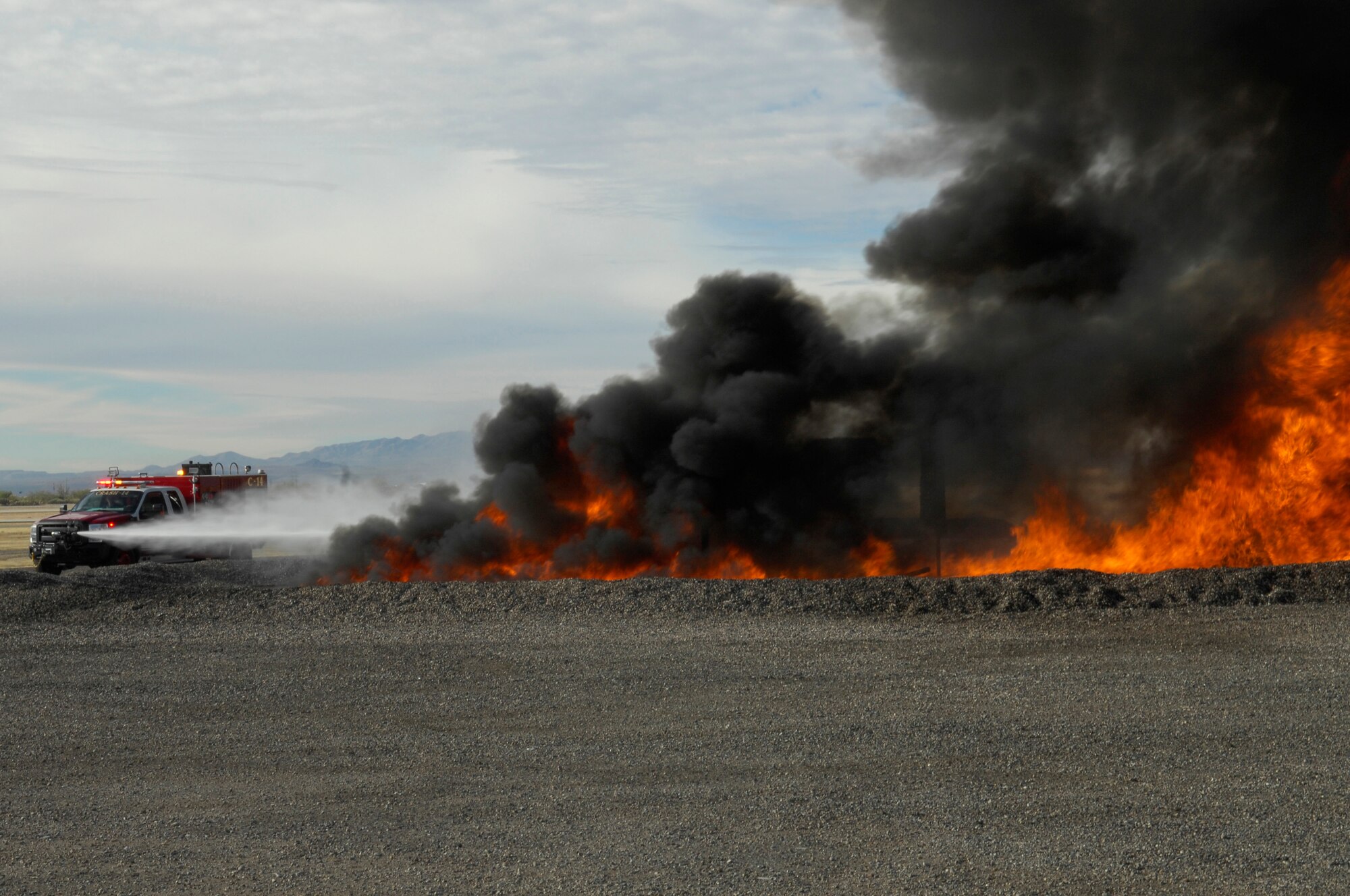 A 355th Civil Engineering Squadron rapid intervention vehicle sprays water on a controlled fire during a training exercise at Davis-Monthan Air Force Base, Ariz., Dec. 10, 2013. The training gave the fire fighters a chance to assess their newest vehicles’ capabilities. (U.S. Air Force photo by Airman 1st Class Betty R. Chevalier/Released) 