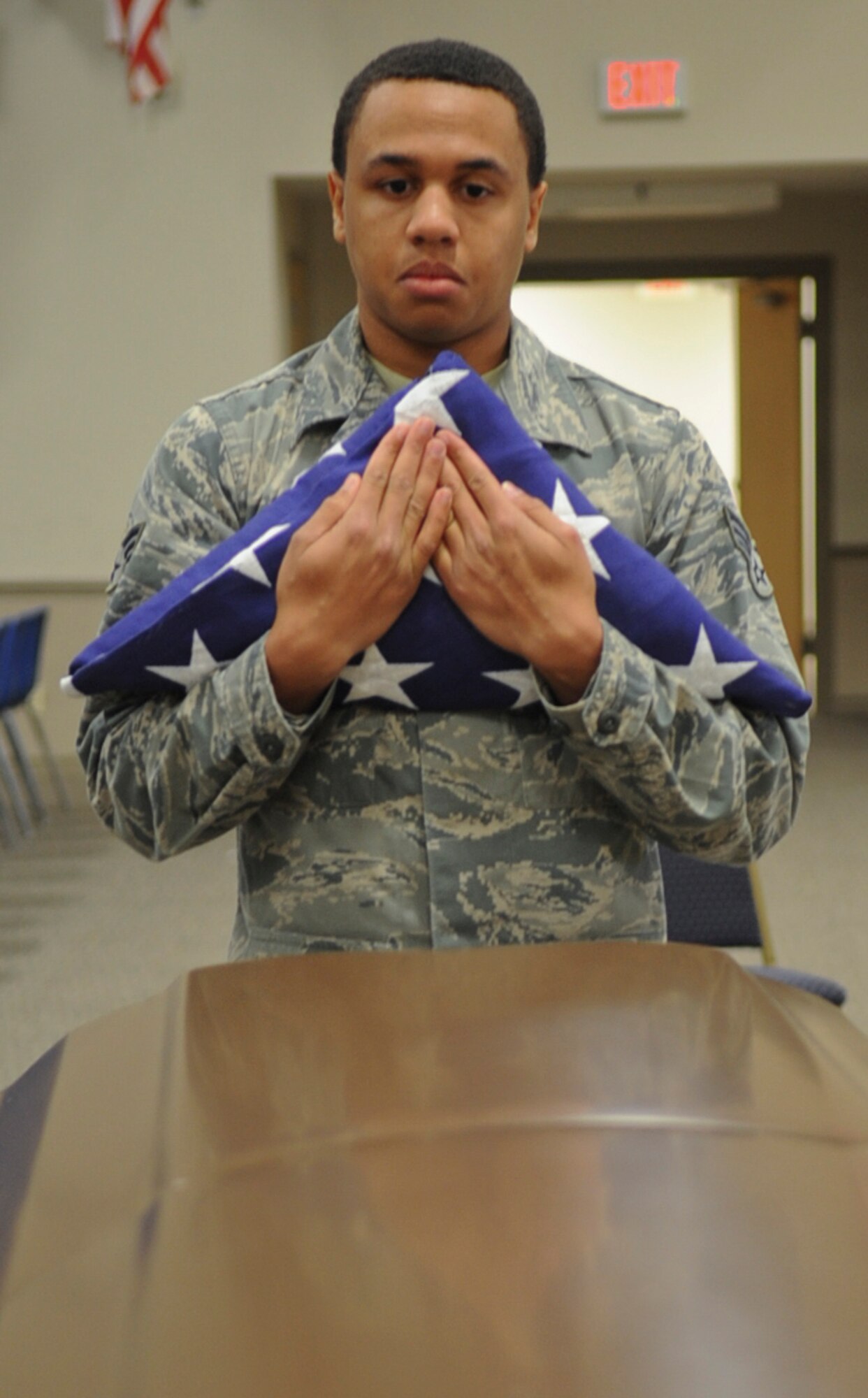 Senior Airman Shawn Morgan , Barksdale Honor Guardsman, awaits the completion of a firing party and TAPS to present the flag to a next-of-kin on Barksdale Air Force Base, La., Dec. 12, 2013. Honor Guard Airmen prepare for moments like this when strong, military bearing is a necessity. Barksdale's Honor Guard covers a 53,000 square mile area ranging from Texas to Louisiana, covering events from funerals, posting and presenting of colors and retirements. (U.S. Air Force photo/Senior Airman Kristin High)