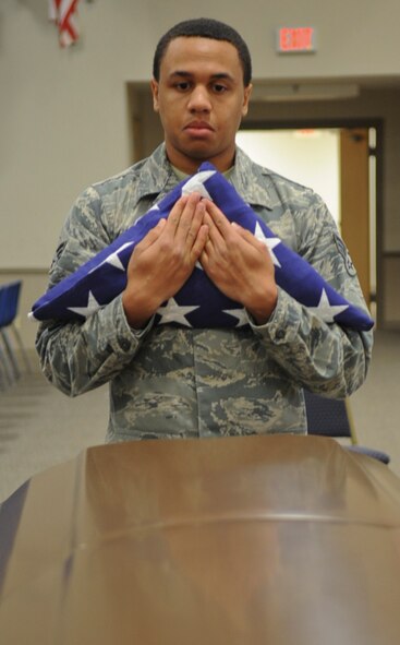Senior Airman Shawn Morgan , Barksdale Honor Guardsman, awaits the completion of a firing party and TAPS to present the flag to a next-of-kin on Barksdale Air Force Base, La., Dec. 12, 2013. Honor Guard Airmen prepare for moments like this when strong, military bearing is a necessity. Barksdale's Honor Guard covers a 53,000 square mile area ranging from Texas to Louisiana, covering events from funerals, posting and presenting of colors and retirements. (U.S. Air Force photo/Senior Airman Kristin High)