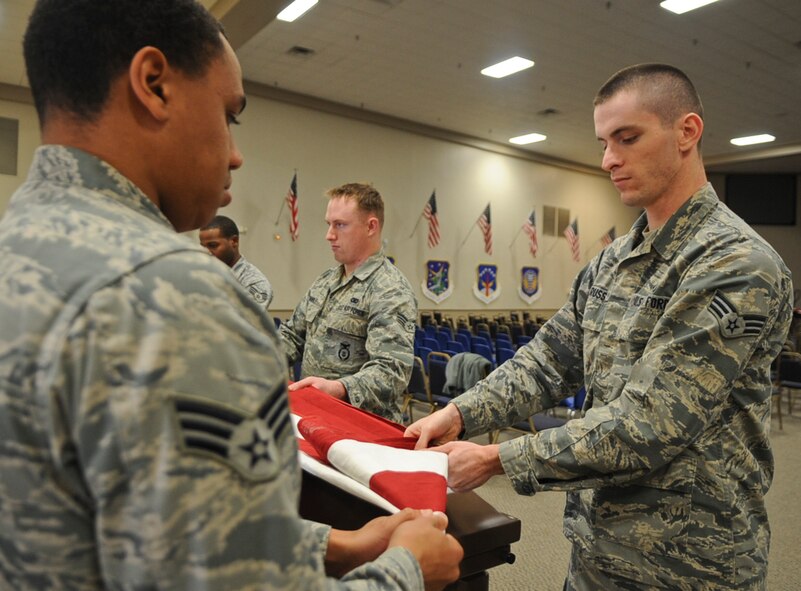 Members from the Barksdale Honor Guard begin a flag folding procedure on Barksdale Air Force Base, La., Dec. 12, 2013. Honor Guard Airmen perform a variety of ceremonies to honor veterans and retirees such as retirement ceremonies, promotion ceremonies, service as pall-bearers and public events.  (U.S. Air Force photo/Senior Airman Kristin High)