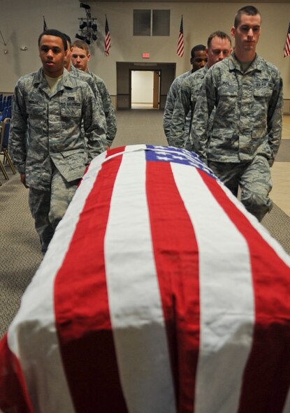 Airmen from the Barksdale Honor Guard approach a hearse to unload a casket on Barksdale Air Force Base, La., Dec. 12, 2013. During their rotation cycles, Honor Guardsmen practice various details daily in order to keep their skills sharp and present a professional image during events they are called to execute. (U.S. Air Force photo/Senior Airman Kristin High)