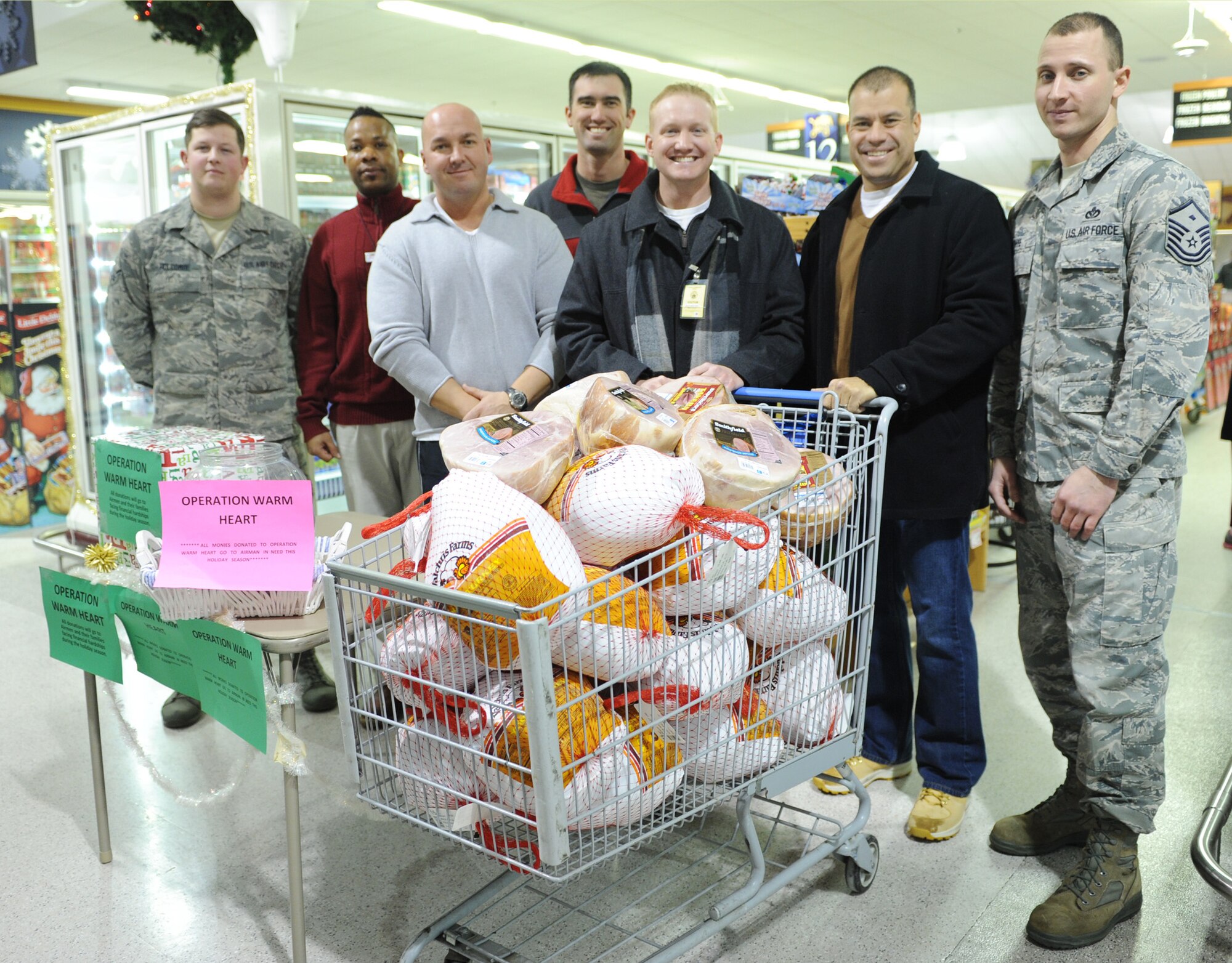 Operation Warm Heart volunteers pose for a photo after purchasing turkeys and hams at the Malmstrom Air Force Base Commissary on Dec. 10. Malmstrom Air Force Association Chapter 108 and Malmstrom first sergeants hosted the annual event, which provides meals for Team Malmstrom members and the Great Falls Rescue Mission during the holidays. Pictured from left to right are, Airman 1st Class Jordan Holcombe, 341st Medical Operations Squadron public health technician and OWH scheduler; Alex Waldon, Malmstrom Commissary store administrator; Staff Sgt. Remigiusz Czelny, 341st Missile Maintenance Squadron security manager and OWH volunteer; Capt. Pat McAfee, 341st MMXS facilities flight commander and OWH volunteer; 1st Lt. Lee Feldhausen, 10th Missile Squadron missile combat crew commander and AFA Chapter 108 president; Senior Master Sgt. Mario Saenz, 341st Logistics Readiness Squadron superintendent and AFA Chapter 108 vice president; and Master Sgt. Bradley Thye, 341st Medical Group first sergeant and event director. (U.S. Air Force photo/Senior Airman Katrina Heikkinen) 