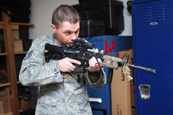 Staff Sgt. Daniel Fisher, 341st Security Forces Group Tactical Response Force Armory assistant NCO in charge, demonstrates looking through a scope whilst correctly handling an M4 carbine at Bldg. 250 on Nov. 21. Fisher supervises all certified armory members in TRF by ensuring they maintain qualifications on various weapon systems and complete regular pro-efficiency firing. (U.S. Air Force photo/Senior Airman Katrina Heikkinen) 