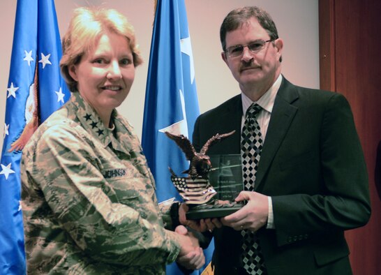 Academy Superintendent Lt. Gen. Michelle Johnson (left) presents an award to Martin Johnson, an electronics engineer from the Dean of Faculty, who was was named Safety Individual of the Year at the Academy Dec. 11 during an awards presentation. The Annual Safety Awards recognize outstanding individuals, units and groups for their contribution to the USAFA Safety program. (U.S. Air Force Photo/Senior Airman Veronica Ward)