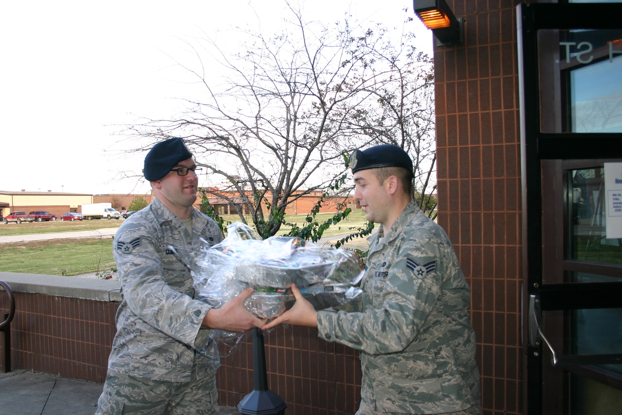 Senior Airmen Joshua Clark, left, and Daniel Crummy, both from the 509th Security Forces Squadron, help load Thanksgiving baskets Nov. 15, 2013, at Whiteman Air Force Base, Mo. Clark and Crummy are both part of Whiteman Airman Leadership School class 14-A. (Contributed U.S. Air Force photo by Senior Airman Chelsea Rittenhouse/Released) 