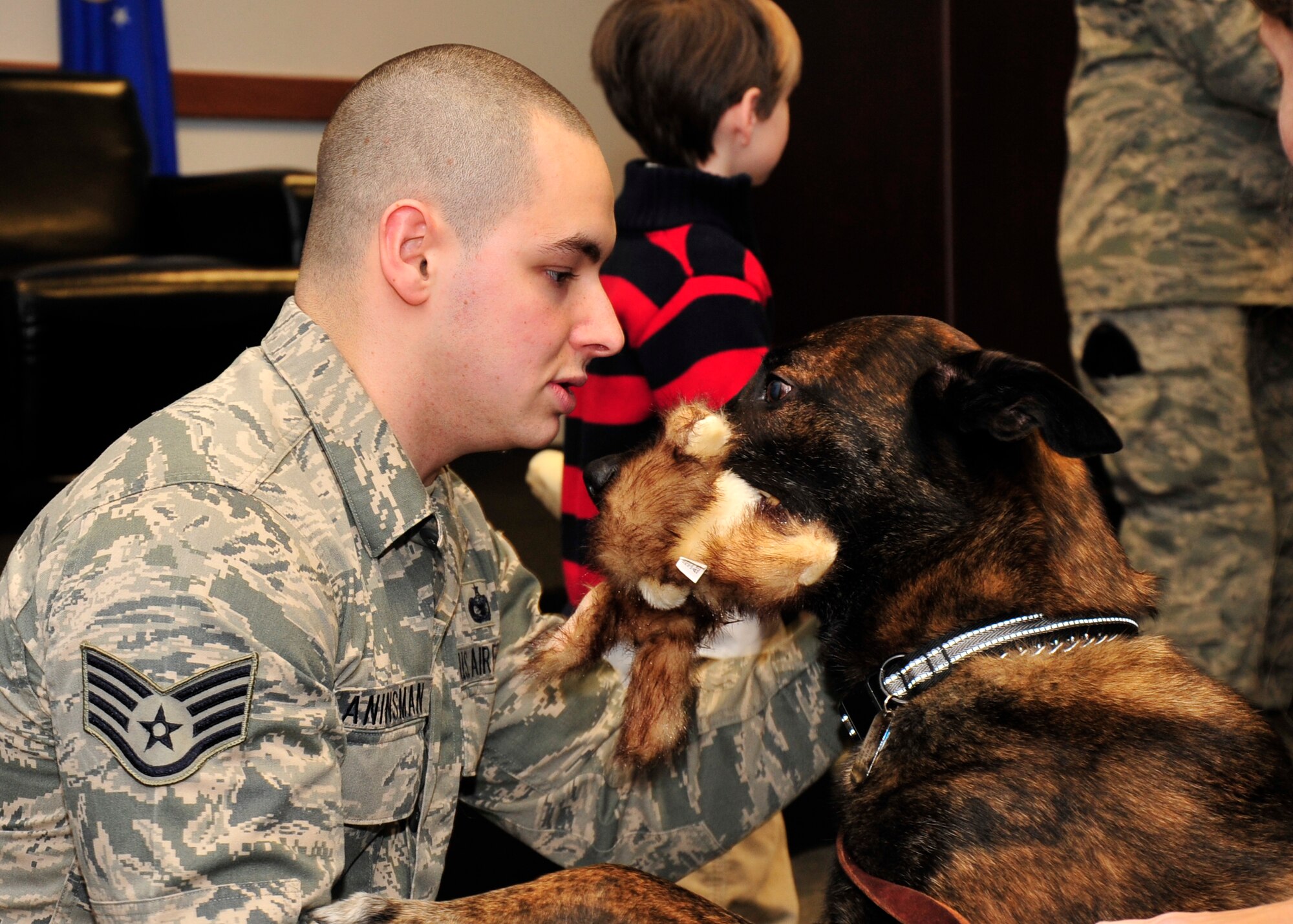 Staff Sgt. Andrew Aninsman, 436th Security Forces Squadron military working dog handler, pets his former military working dog, Lance, Dec. 11, 2013, at Dover Air Force Base, Del. Lance retired after serving nine years as a military working dog. (U.S. Air Force Photo/Airman 1st Class William Johnson)