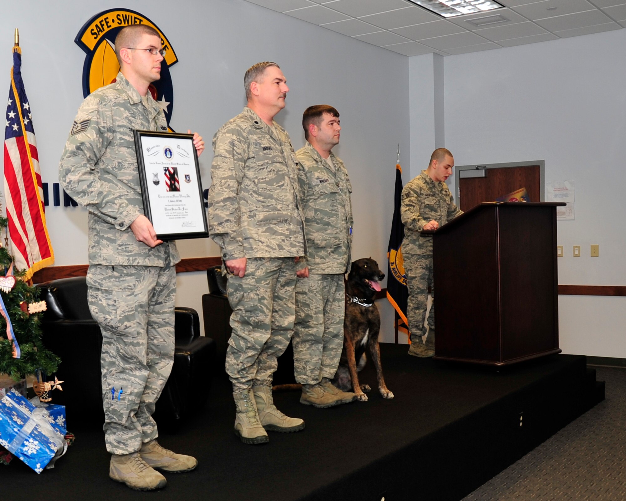 Staff Sgt. Andrew Aninsman, 436th Security Forces Squadron military working dog handler, retires Lance, a military working dog, Dec. 11, 2013, at Dover Air Force Base, Del. Lance was adopted by Tech. Sgt. Ryan Walker, 436th SFS NCO in charge of intelligence, after serving nine years as a military working dog. (U.S. Air Force photo/Airman 1st Class William Johnson)