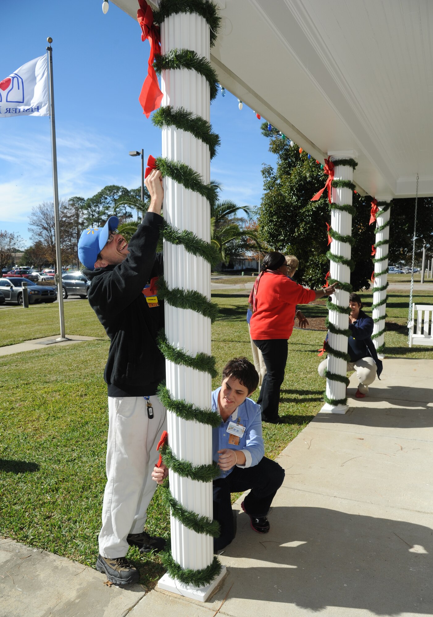 Alex Whitby, JoJo Thrasher and fellow employees from a local Biloxi business decorates the Fisher House for Christmas Dec. 12, 2013, at Keesler Air Force Base, Miss.  The Fisher House Foundation is best known for a network of comfort homes where military and veterans’ families can stay at no cost while a loved one is receiving treatment.  (U.S. Air Force photo by Kemberly Groue)