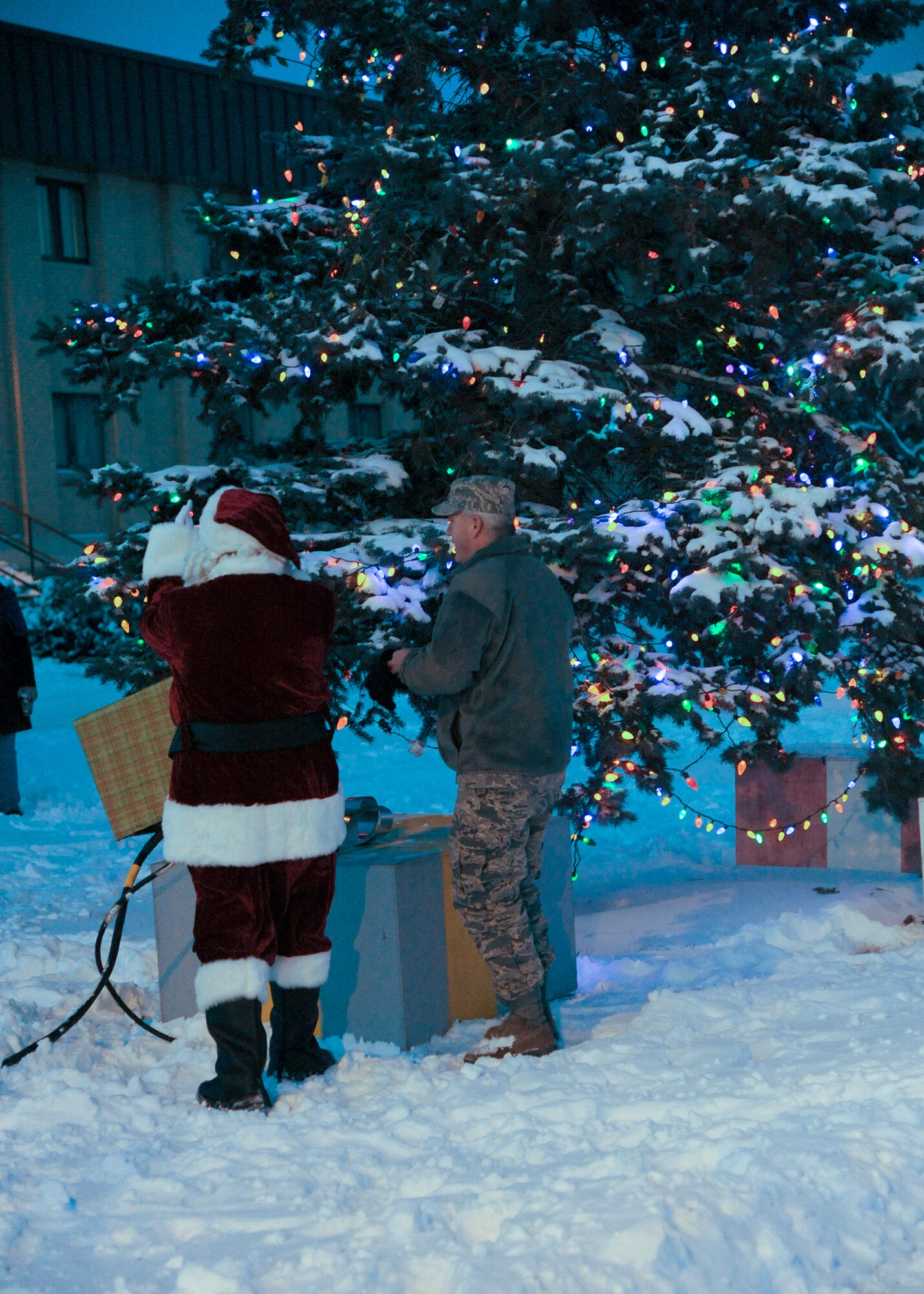 Col. Mark Schuler, 341st Operations Group commander (right), and Santa Clause clap with Team Malmstrom members after lighting a tree outside of Malmstrom's Bldg. 1191 during a ceremony Dec. 5.  The annual tree-lighting ceremony gave the base populace a chance to get together with each other and their dependents for a safe kick off to the holiday season.  (U.S. Air Force photo/Senior Airman Cortney Paxton)