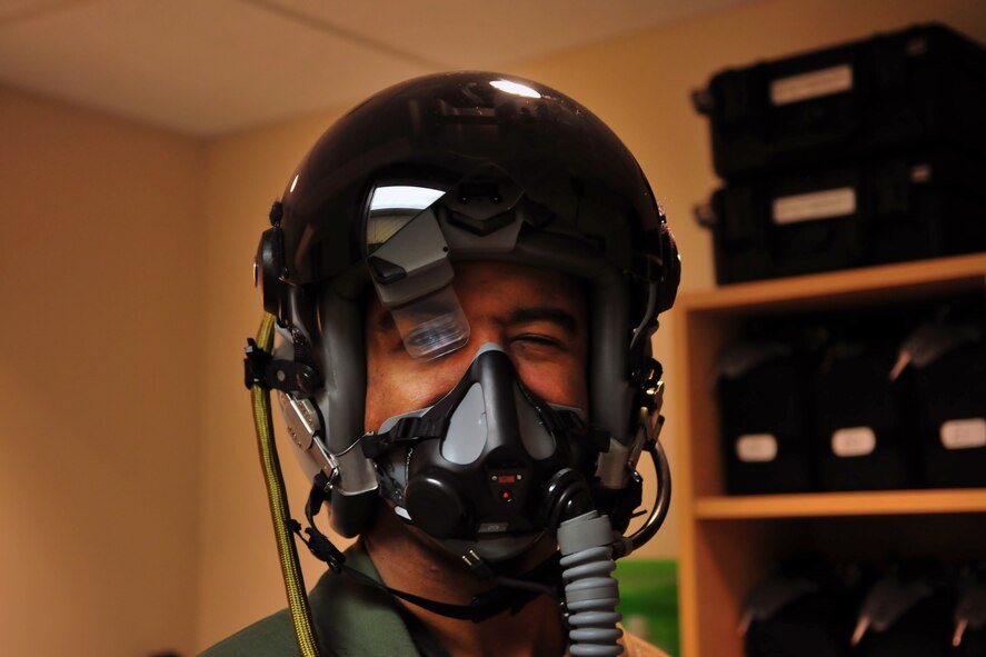1st Lt. Victor McCoy, an F-16 pilot with the 115th Fighter Wing, tests out his Helmet Mounted Cueing System after having it fitted to his helmet at Truax Field, Wis., Dec. 7, 2013.  The HMCS is the only full-color helmet display system and includes optical motion tracking, head-steered weapons, 24-hour day/night capability, it also integrates with older helmets and includes features such as a virtual heads up display or multi-function display capability. (Air National Guard photo by 1st Lt. Stephen Montgomery/Released)