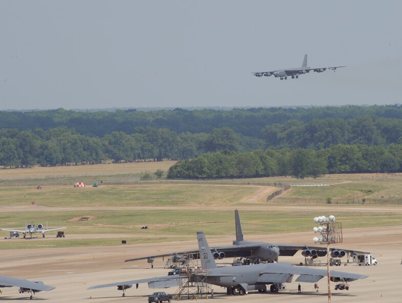 A B-52H Stratofortress approaches the flightline to perform a touch-and-go landing as 2nd Bomb Wing Airmen prepare other B-52H Stratofortress bombers for takeoff during an exercise at Barksdale Air Force Base, La., June 5. The 2nd Bomb Wing was evaluated on its ability to accurately and efficiently perform their mission anytime and anywhere when called upon. (U.S. Air Force photo/Airman 1st Class Benjamin Gonsier)(RELEASED)