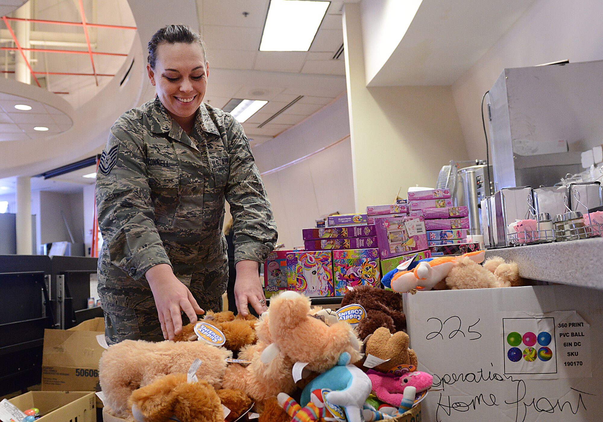 Technical Sergeant Elizabeth O'Connell, 138th Fighter Wing's Airman and Family Readiness Assistant, helps transform the 138th Fighter Wing Aerospace Dining Facility into a one stop shop, offering up thousands of toys to the immediate families of Airman from the 138th Fighter Wing, Tulsa Air National Guard.  Thousands of toys were donated by Family Dollar stores in the local area, as part of Operation Homefront. (U.S. Air Force Photo by Senior Master Sgt. Preston Chasteen/Released)