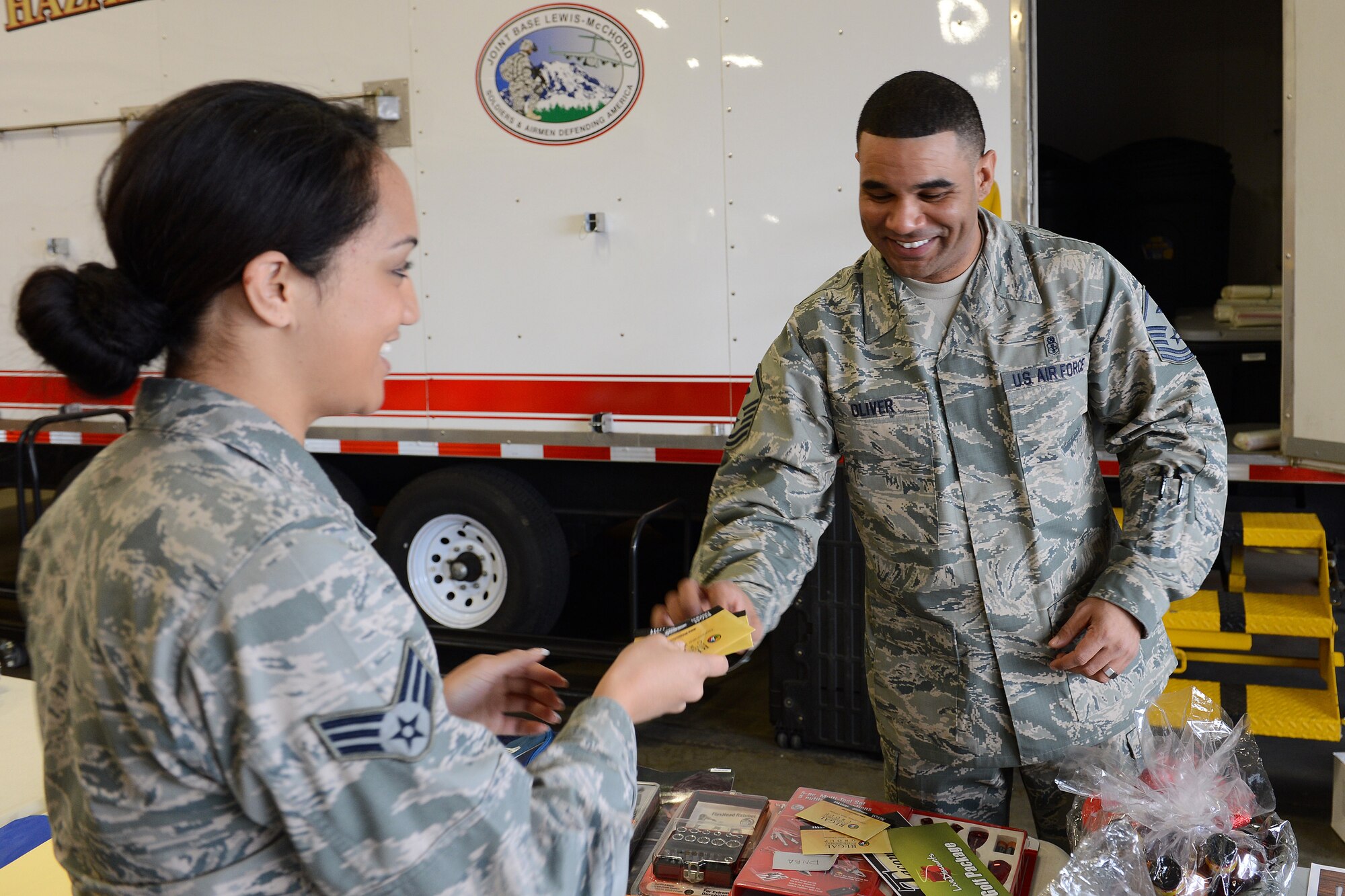 Master Sgt. Calvin Oliver, 10th Airlift Squadron first sergeant, gives out two free movie tickets to Senior Airman Pogisa Faumuina, Western Air Defense Sector military personnel technician, at the Airmen’s Feast Dec. 11, 2013 at Joint Base Lewis-McChord, Wash. During the event Airmen received a free lunch and a variety of raffle prizes. (U.S. Air Force photo/Airman 1st Class Jacob Jimenez)