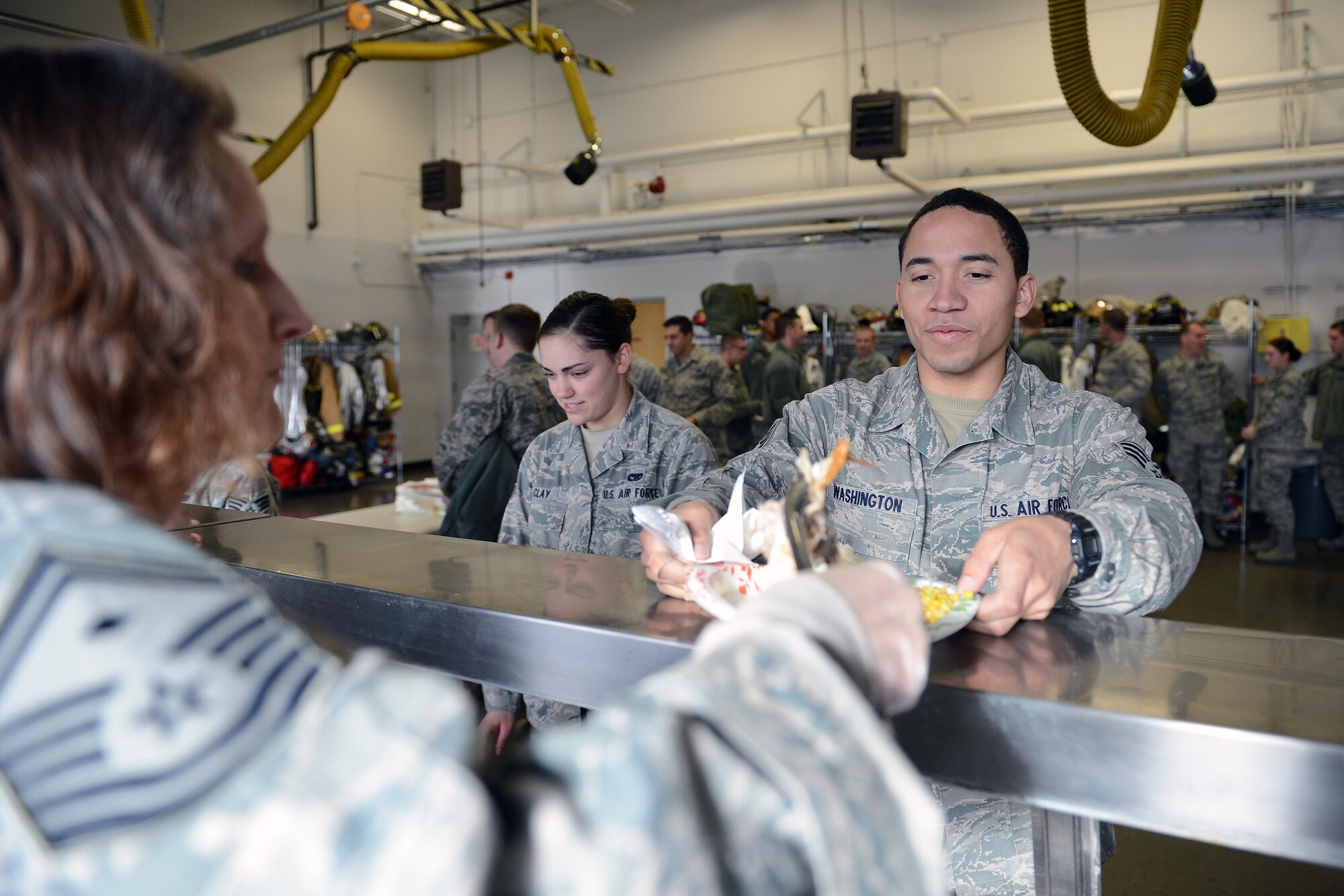 Senior Airman Jerome Washington, 627th Logistics Readiness Squadron inventory technician, is served turkey by Senior Master Sgt. Angela Fernandez, 62nd Aerial Port Squadron first sergeant, at the Airmen’s Feast Dec. 11, 2013 at Joint Base Lewis-McChord, Wash. The event was organized by the Team McChord First Sergeants Association. (U.S. Air Force photo/Airman 1st Class Jacob Jimenez) 