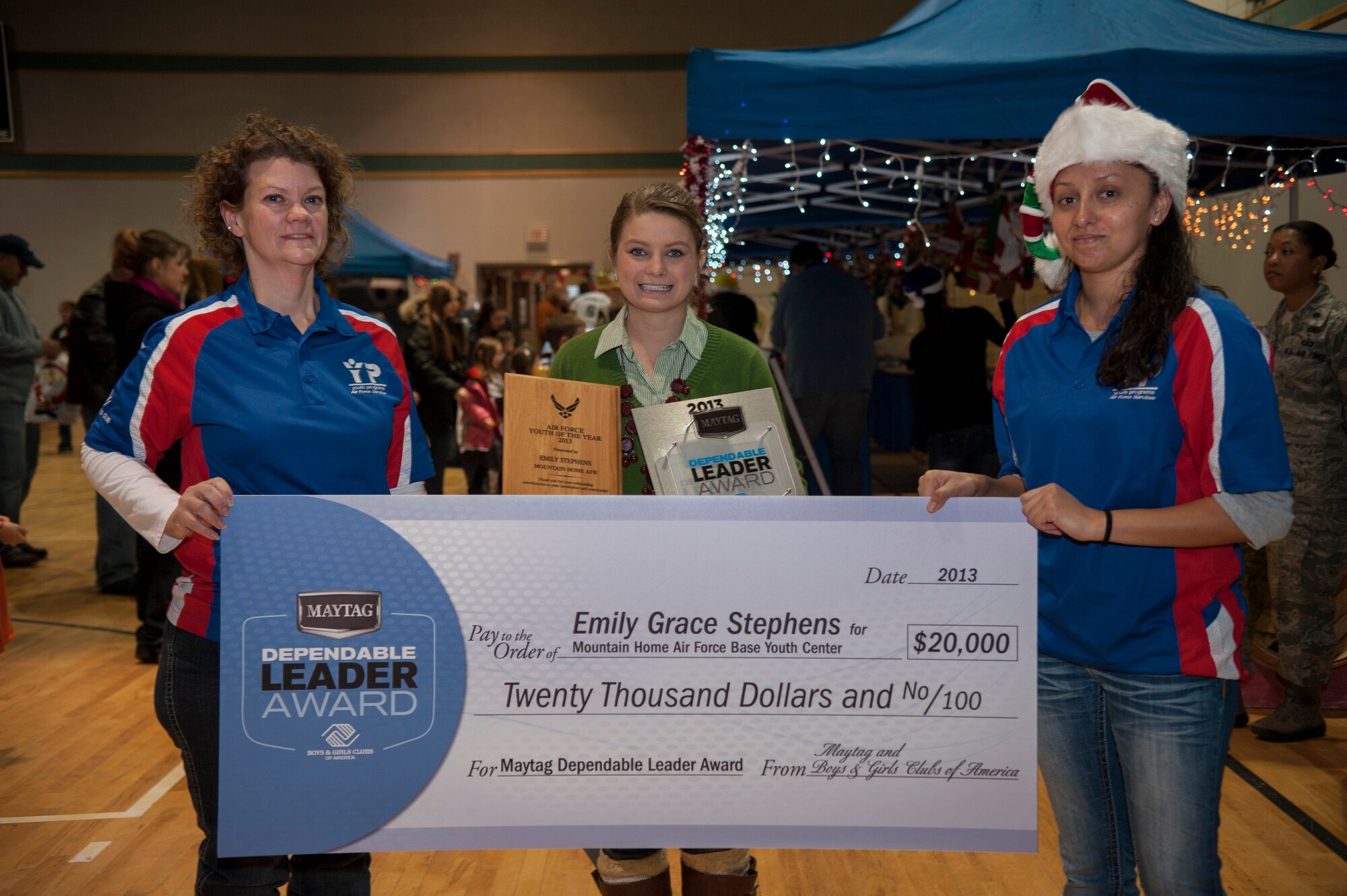 From left to right, Chartelle Eichman, 366th Force Support Squadron Youth Center director, Emily Stephens and Vanessa Gil, 366th FSS child and youth program assistant, hold a $20,000 check after Stephens was awarded the 2013 Maytag Dependable Leader Award at Mountain Home Air Force Base, Idaho, Youth Center Nov. 7, 2013. The grant will give MHAFB YC the opportunity to increase the video and graphic design equipment to provide valuable skills and opportunities for base youth. (U.S. Air Force photo by Staff Sgt. Roy Lynch/Released)