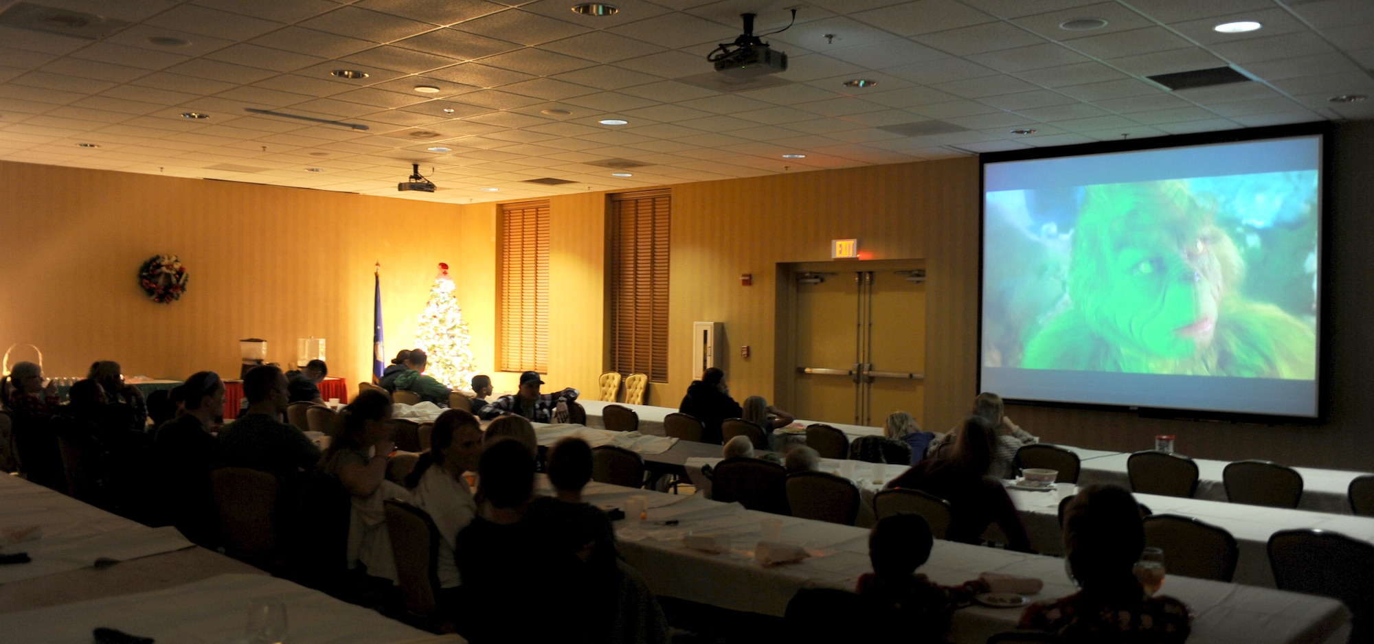 Families attending the "Pasta and Pajama Holiday Celebration" watch "How the Grinch Stole Christmas" at the Mirage Club, Davis-Monthan Air Force Base, Ariz., Dec. 10, 2013.  Popcorn, cookies and cotton candy were provided to approximately 50 people during the movie. (U.S. Air Force photo by Airman 1st Class Chris Massey/Released)
