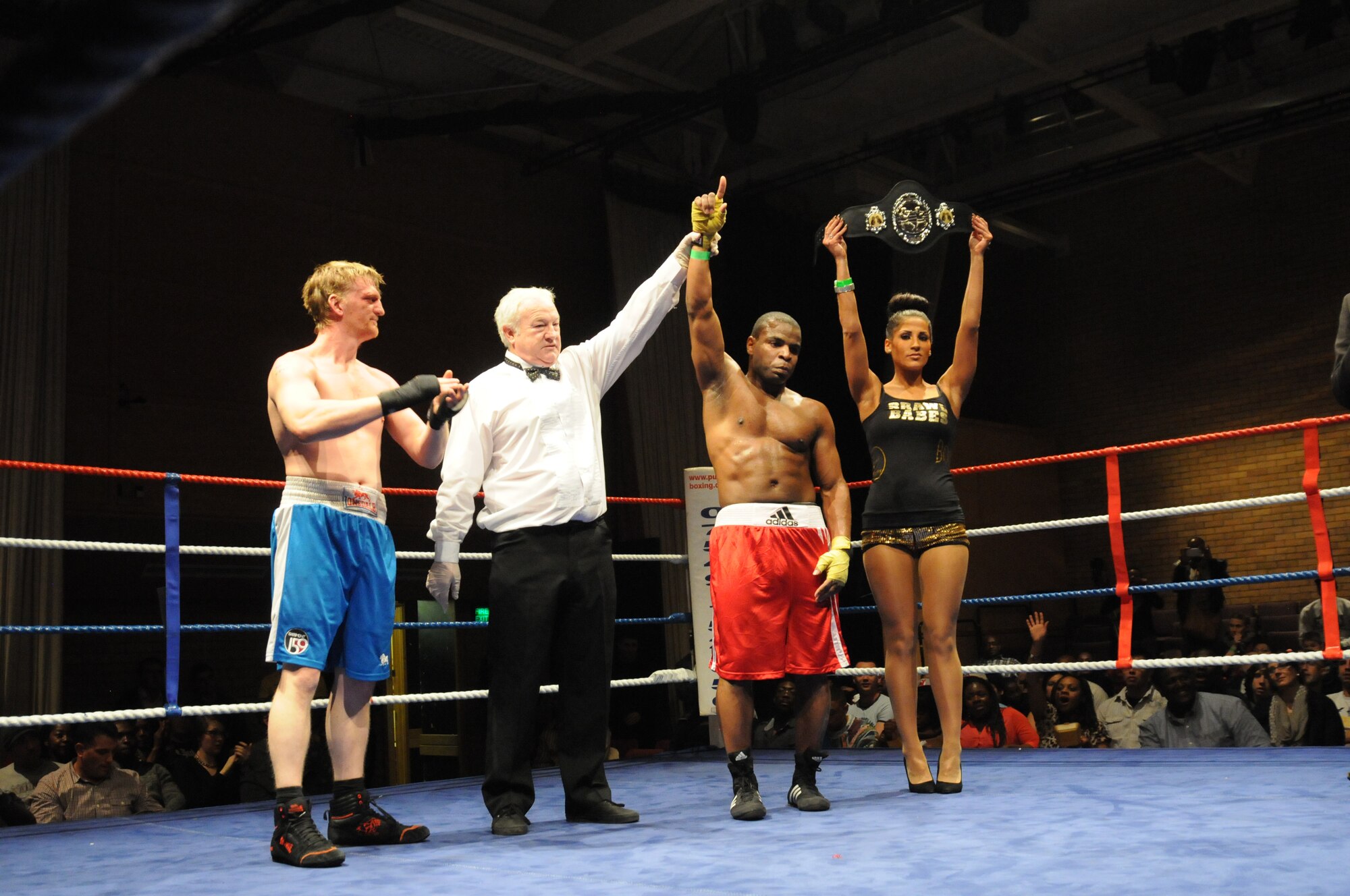 U.S. Air Force Staff. Sgt. James Beck, 76th Airlift Squadron, raises his hand after winning his boxing match for the eastern area middle-weight title in Huntingdon, England, Dec. 7, 2013. The match was one of several held during an independent event that pitted U.S. Airmen against U.K. fighters. The event raised funds for several charities. (U.S. Air Force photo by Tech. Sgt. Neal X. Joiner/Released)