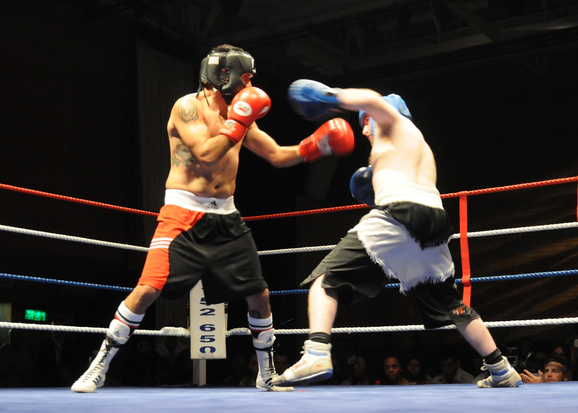 Marty Kayes, right, throws a punch at U.S. Air Force Tech. Sgt. Richard Mora, 100th Aircraft Maintenance Squadron from Oceanside, Calif., during a boxing match for the White Collar Boxing Cambridge light middle-weight title Dec. 7, 2013, in Huntingdon, England. The match was one of several held during an independent event that pitted U.S. Airmen against U.K. fighters. The event raised funds for several charities. (U.S. Air Force photo by Tech. Sgt. Neal X. Joiner/Released)