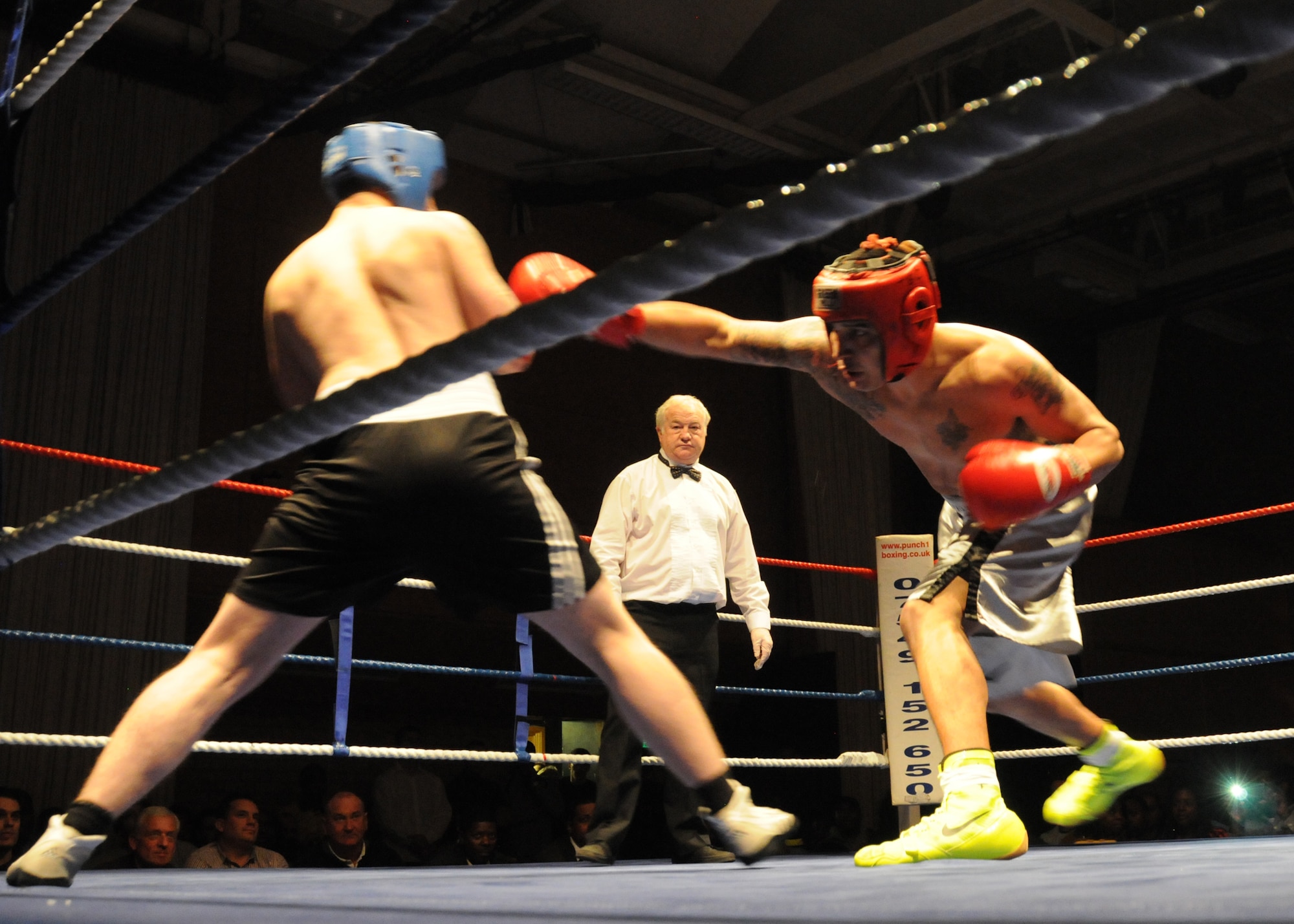 U.S. Air Force Senior Airman Oscar Campos-Ortiz, right, 100th Communication Squadron from Dallas, throws a punch during a boxing match Dec. 7, 2013, in Huntingdon, England. The match was one of several held during an independent event that pit U.S. Airmen against British and Irish fighters. The event helped raise funds for several charities. (U.S. Air Force photo by Tech. Sgt. Neal X. Joiner/Released)