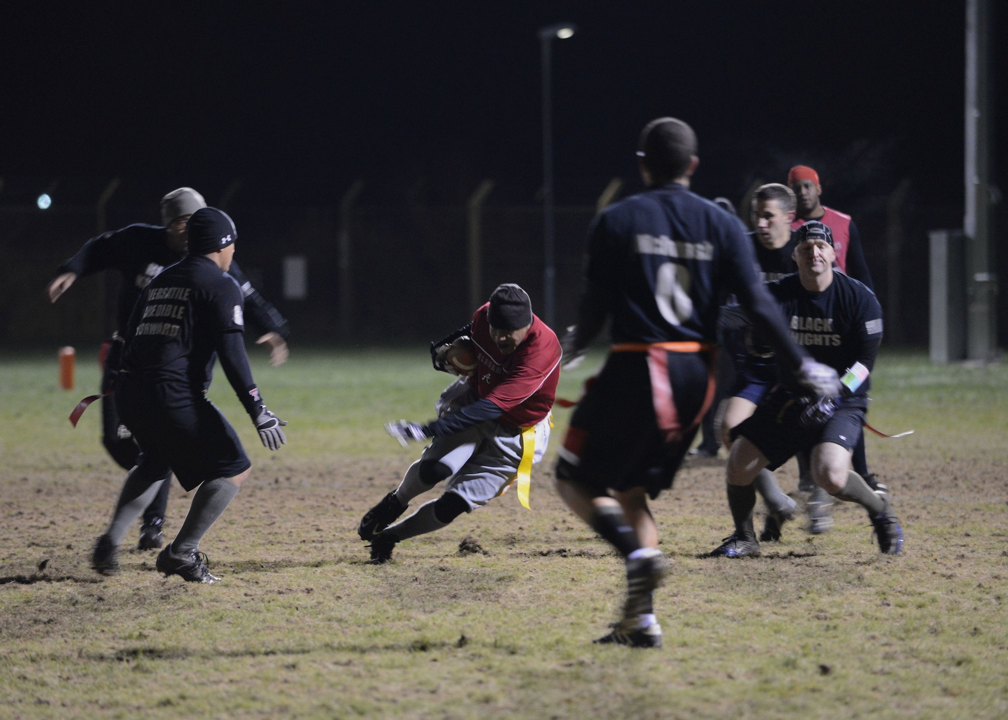 A player with the 100th Communications Squadron intramural flag football team evades the Black Knights, the 352nd Special Operations Support Squadron intramural flag football team, Dec. 6, 2013, during the Intramural Football Championship on RAF Mildenhall, England. The 352nd SOSS competed in two final games against the 100th CS for the championship winning 22-12 and 13-12. (U.S. Air Force photo by Airman 1st Class Preston Webb/Released)