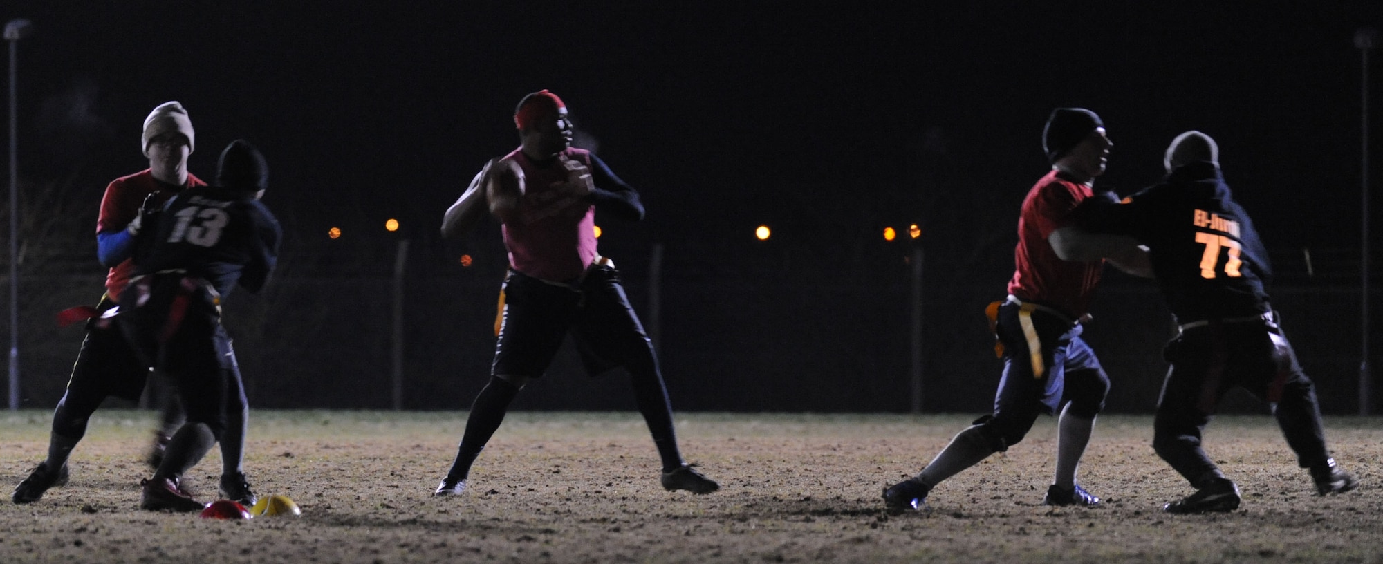 Travis Vernon, center, 100th Communications Squadron team quarterback, scans the field Dec. 6, 2013, during the Intramural Football Championship on RAF Mildenhall, England. The 352nd Special Operations Support Squadron defeated the 100th CS with a score of 22-12, sending the teams into a tie-breaking game. (U.S. Air Force photo by Airman 1st Class Preston Webb/Released)