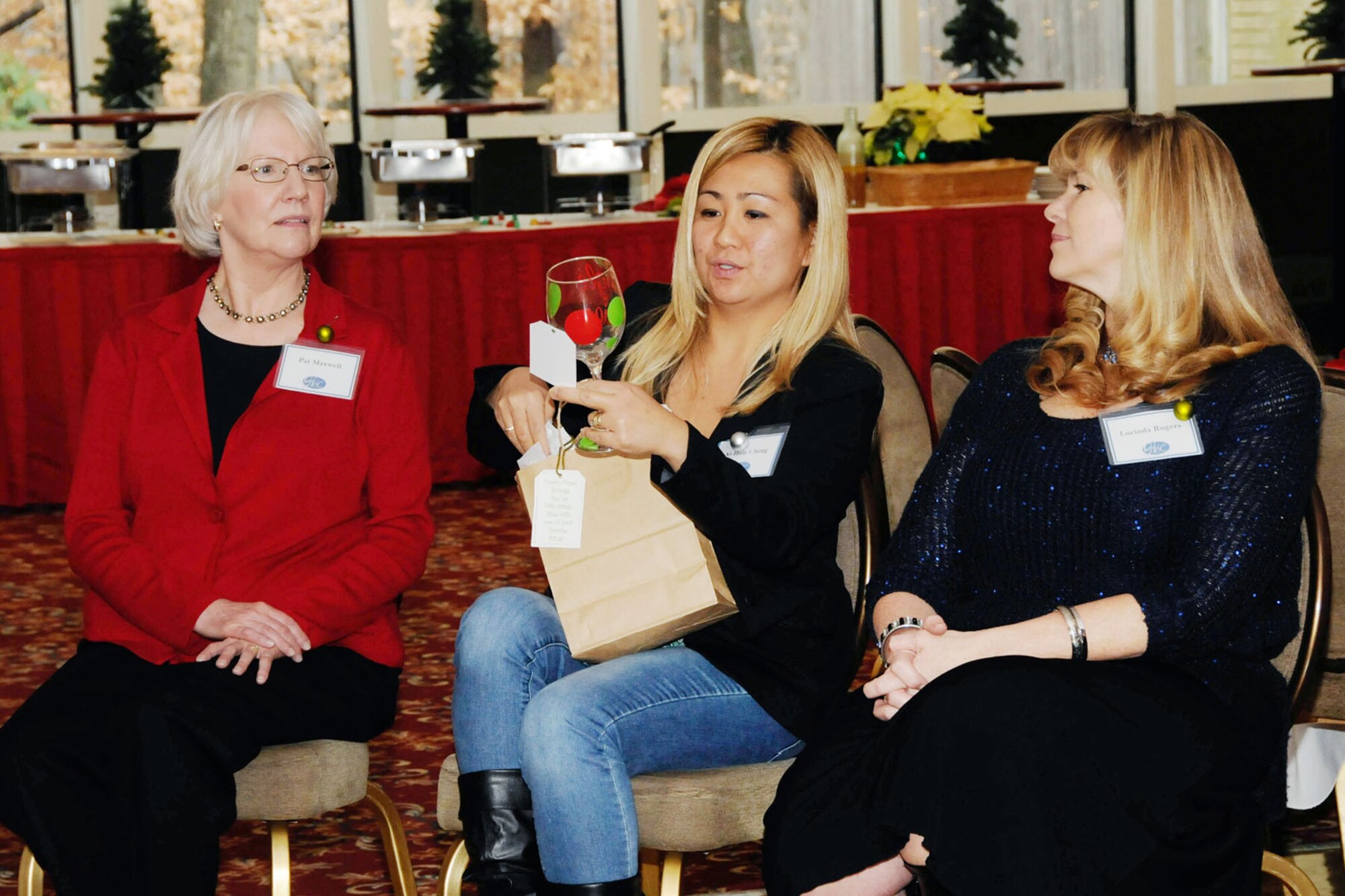 Pat Maxwell (left), Ai-Hsin Cheng (middle) and Lucinda Rogers, members of Hanscom Spouse Club, take part in the HSC annual Favorite Things Holiday Swap luncheon at the Minuteman Commons, Dec.6. HSC members each brought an unwrapped gift that will be donated to the Airman and Family Readiness Center to assist the local community during events. (U.S. Air Force photo by Linda LaBonte Britt)