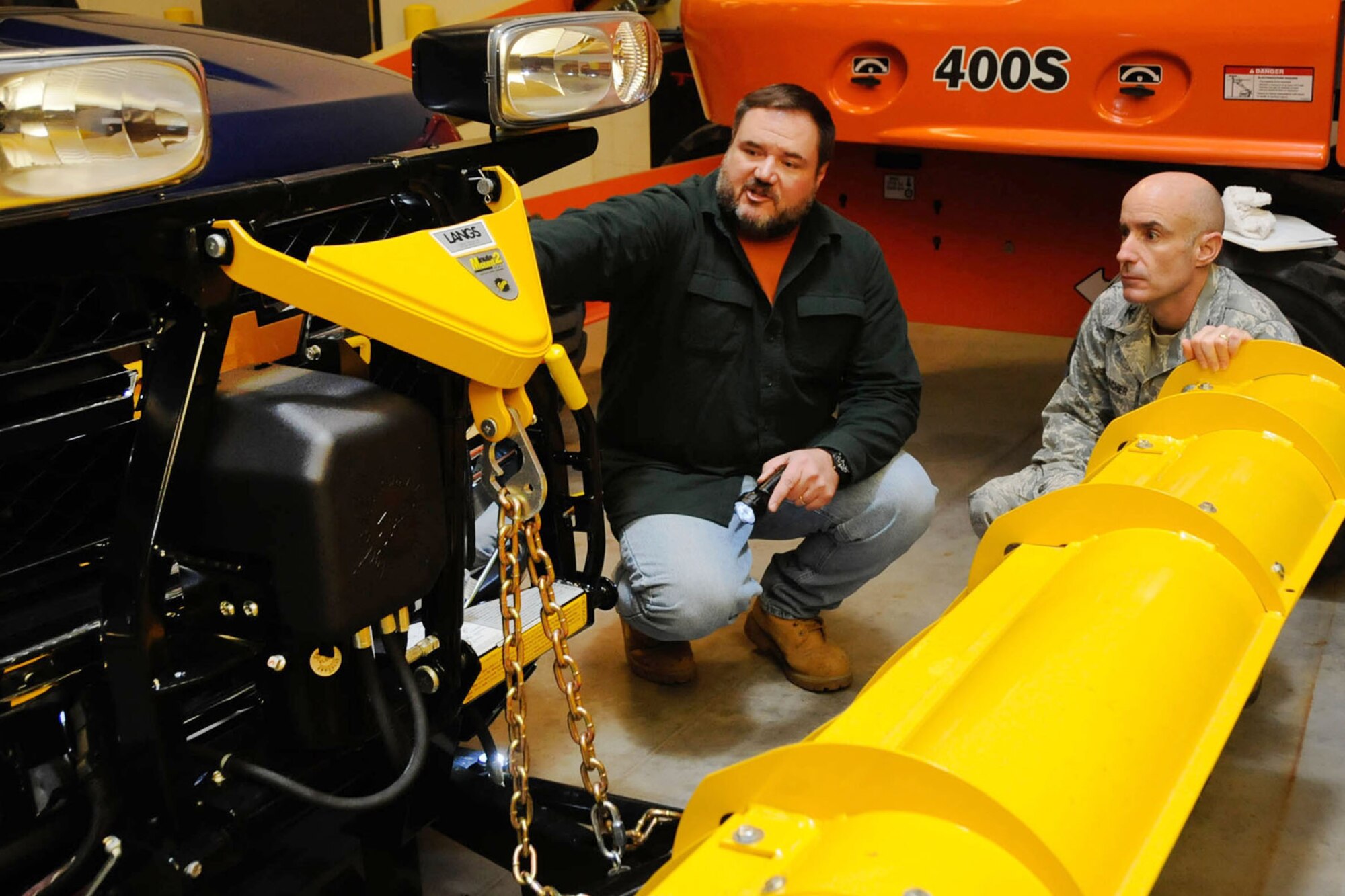 Michael Delancey (left), Civil Engineering heavy equipment supervisor, explains to Col. Lester A. Weilacher, 66th Air Base Group commander, procedures to maintain snow removal equipment during snow storms at the CE complex, Dec. 6. Any issues regarding base snow removal can be addressed by calling 781-377-3383. (U.S. Air Force photo by Linda LaBonte Britt)