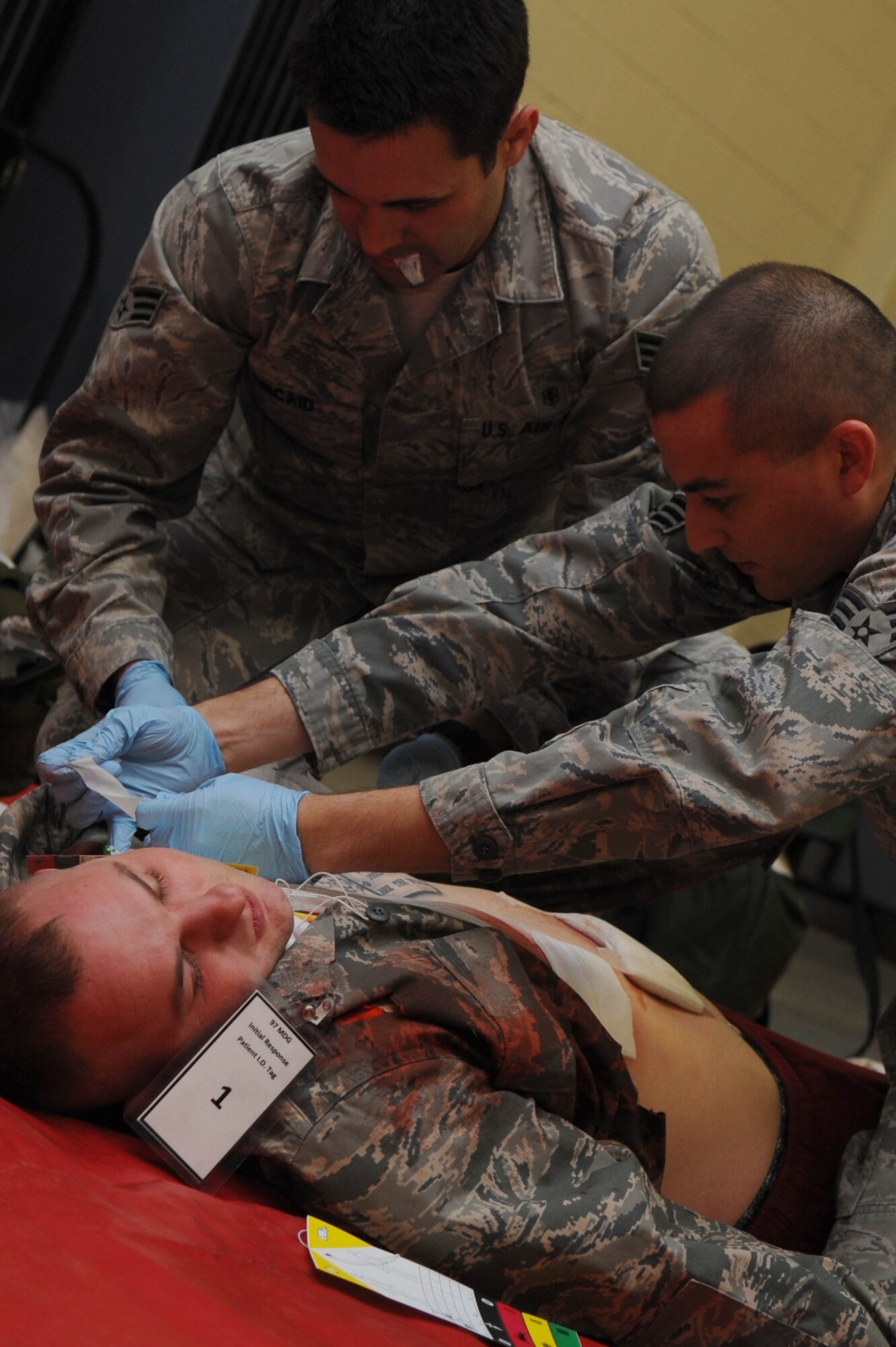 ALTUS AIR FORCE BASE Okla. – U.S. Air Force Senior Airman Scott Kincaid and U.S. Air Force Senior Airman Andrew Bean, 97th Medical Operations Squadron aerospace medical technicians, treat the wounds of U.S. Air Force Senior Airman James Kelleher, 97th Maintenance Directorate crew chief, during an active-shooter exercise Dec. 11, 2013. The exercise tested first responders as well as medical group personnel on their response in the event of an active shooter. (U.S. Air Force photo by Airman 1st Class Klynne Pearl Serrano/Released)