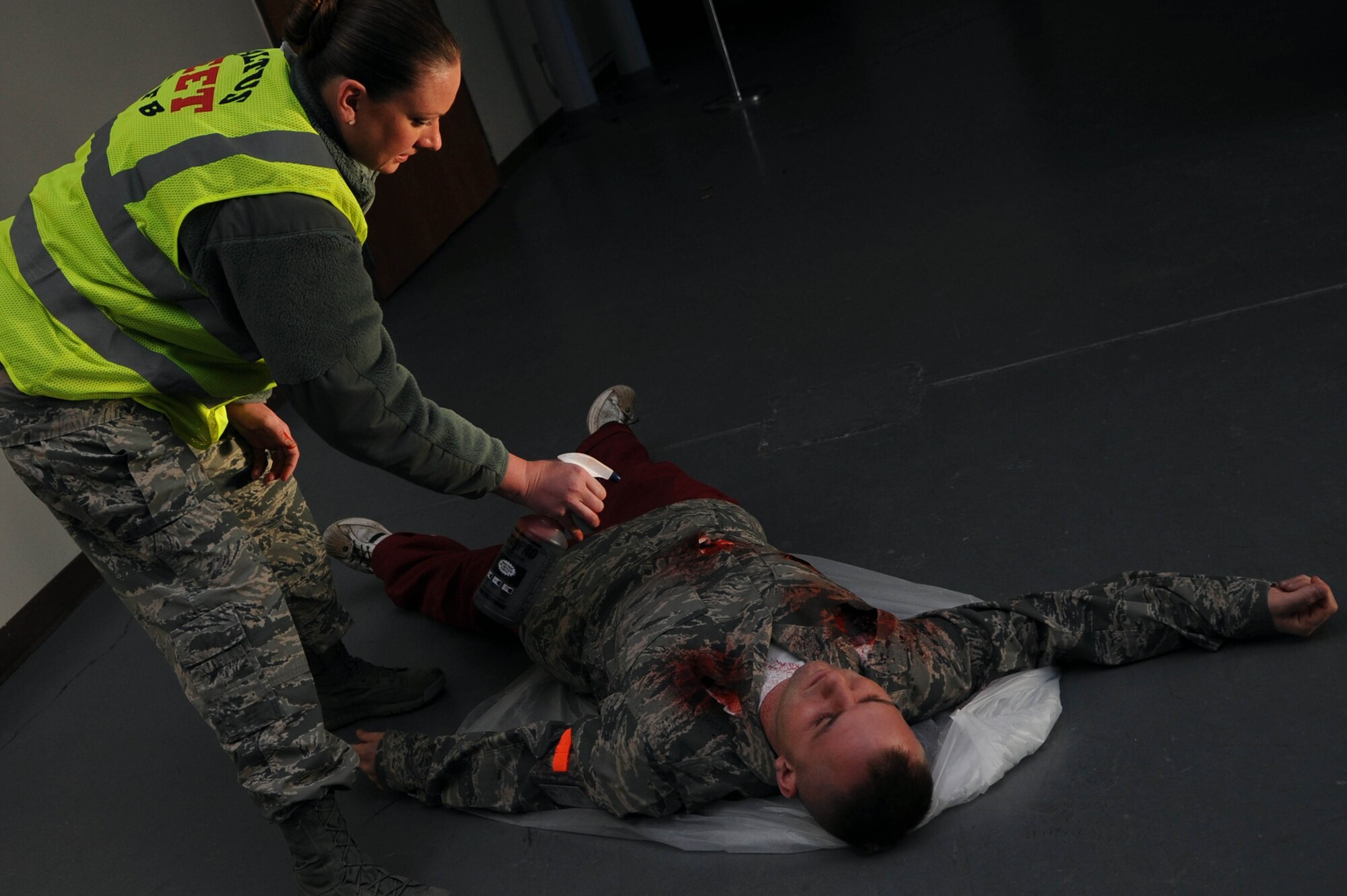 ALTUS AIR FORCE BASE Okla. – U.S. Air Force Master Sgt. Anna Nelson, 97th Medical Group NCO in charge of education and training, sprays fake blood on U.S. Air Force Senior Airman James Kelleher, 97th Maintenance Directorate crew chief, as part of an active-shooter exercise Dec. 11, 2013 Bases across the Department of Defense train for events like these to prevent unnecessary loss of life.  (U.S. Air Force photo by Airman 1st Class Klynne Pearl Serrano/Released)