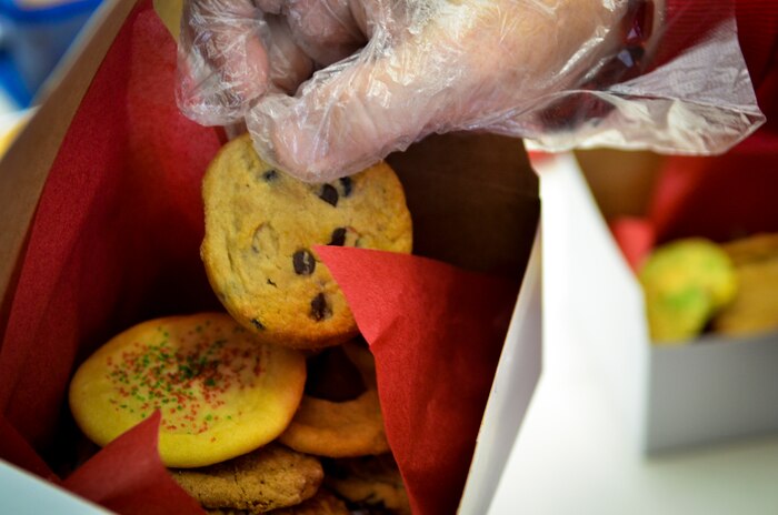 A member of the Team Charleston Spouses Club adds another cookie to one of many boxes of cookies and edible goodies being sent to Joint Base Charleston deployed Airmen Dec.11, 2013, at the Air Base Chapel Annex on Joint Base Charleston — Air Base, S.C. The Team Charleston Spouses Club collected more than 6,500 cookies and edible goods to be distributed to deployed members Joint Base Charleston, the Gaylor Dining Facility and the Naval Weapon Station Galley. (U.S. Air Force photo/Airman 1st Class Michael Reeves)
