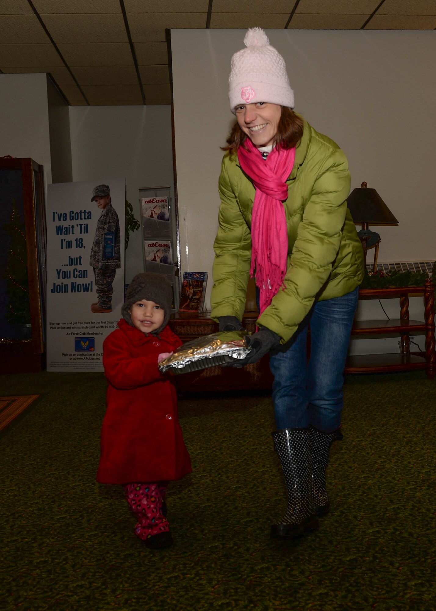 Eleanor Pierson, 3, and Danielle Pierson, family of Capt. Michael Pierson, 48th Fighter Wing legal office assistant judge advocate, carry cookies donated to the annual Combat Cookie Drive on Royal Air Force Lakenheath, England, Dec. 11, 2013. The Combat Cookie Drive supplies Airmen who live in the dorms and deployed personnel with a little taste of home during the holiday season. (U.S. Air Force photo by Airman 1st Class Nigel Sandridge/ Released) 