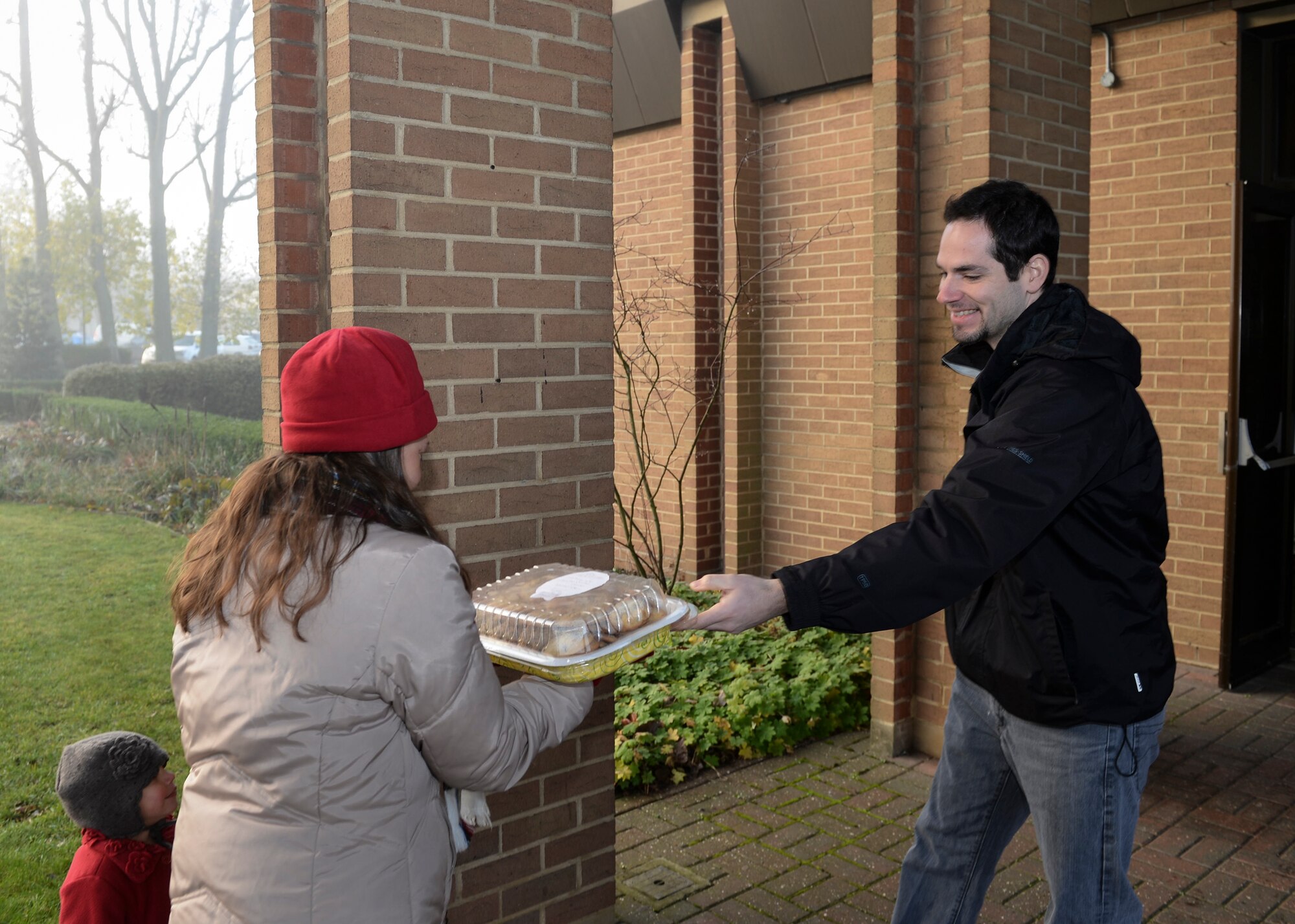 Michael Rachanow, 48th Civil Engineer Squadron project programmer, drops off cookies made by his wife, Katherine Rachanow, for the annual Combat Cookie Drive on Royal Air Force Lakenheath, England, Dec. 11, 2013. The Combat Cookie Drive supplies Airmen who live in the dorms and deployed personnel with a little taste of home during the holiday season. (U.S. Air Force photo by Airman 1st Class Nigel Sandridge/ Released)