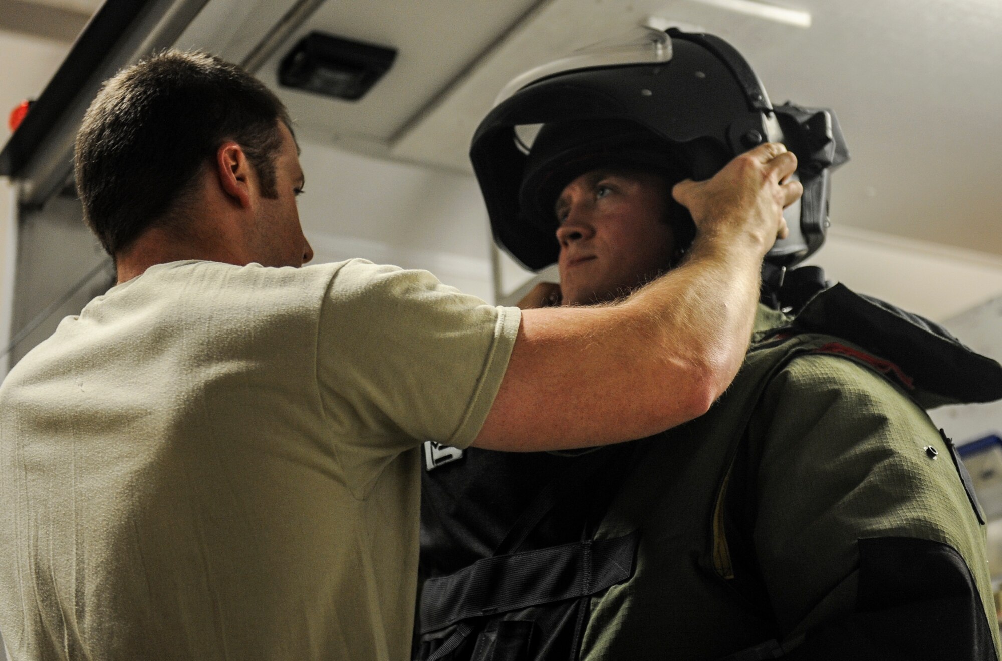 Tech Sgt. Kyle Miller, a 19th Civil Engineer Squadron explosive ordnance technician, aids Staff Sgt. Warren Long, a 19th CES explosive ordnace technician in applying the helmet and mask to the bomb suit Nov. 8, 2013, at Little Rock Air Force Base, Ark. The EOD team must become comfortable performing strenuous tasks in the suit in order to be effective EOD technicians. (U.S. Air Force photo by Staff Sgt. Jessica Condit)