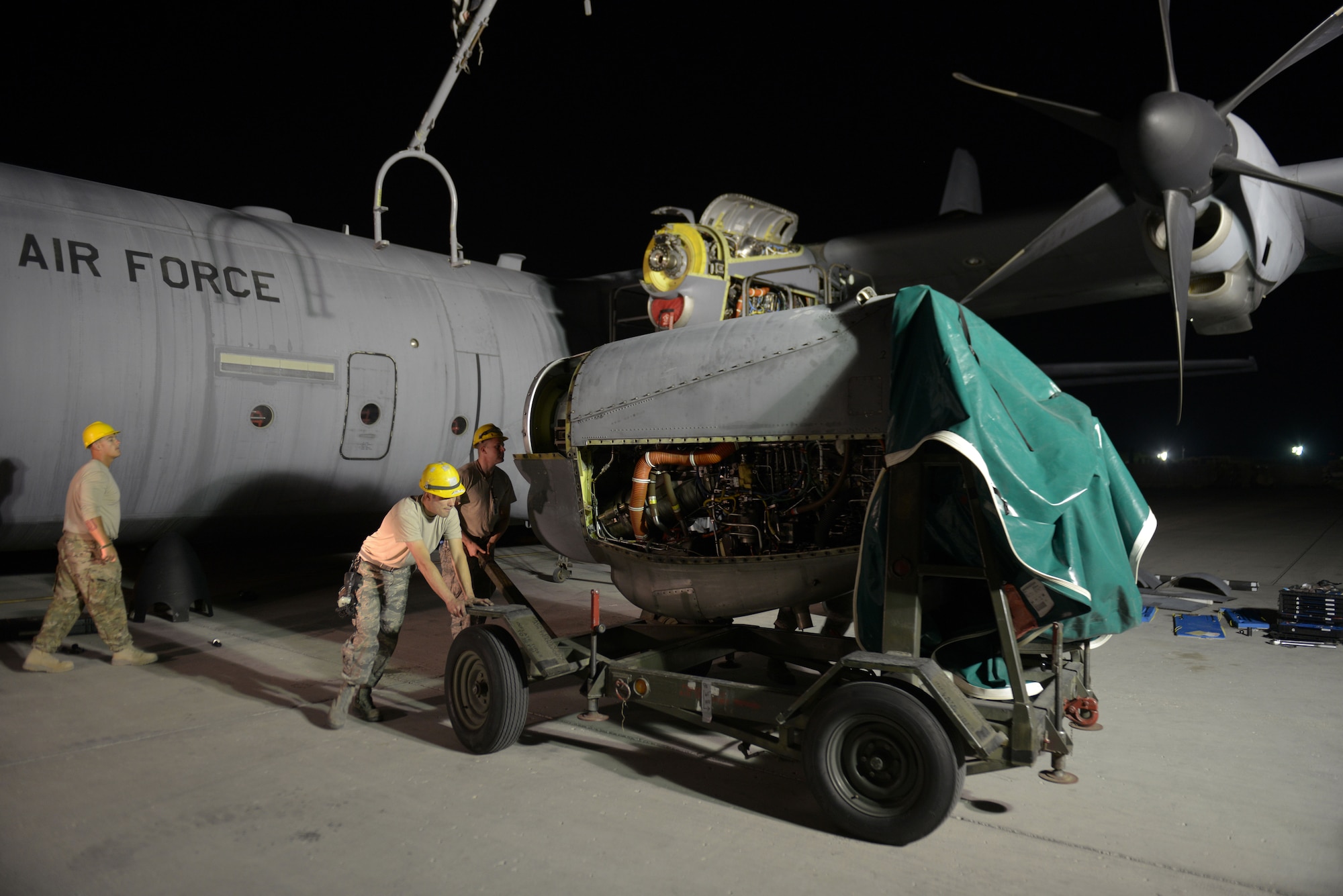 Airmen from the 379th Expeditionary Aircraft Maintenance Squadron, 746th Expeditionary Aircraft Maintenance Unit propulsion flight, remove an  engine after a C-130 engine swap at the 379th Air Expeditionary Wing, Southwest Asia, Dec. 11, 2013. The engine was swapped in 12 hours and the aircraft was ready to fly on schedule. (U.S. Air Force photo/Master Sgt. David Miller)