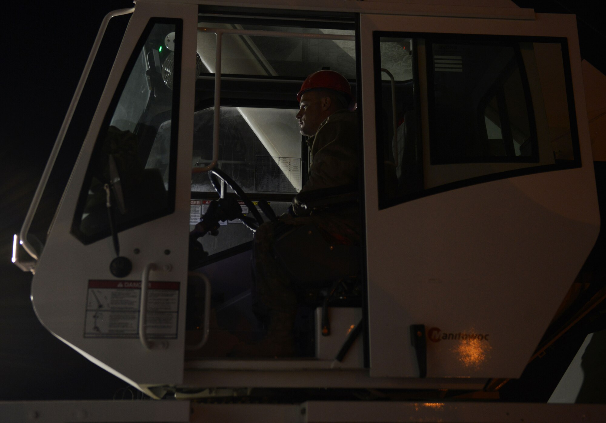 Staff Sgt. Daniel Fox, 557th Expeditionary Red Horse Squadron heavy equipment operator, controls a crane during an engine swap by members of the 379th Expeditionary Aircraft Maintenance Squadron, 746th Expeditionary Aircraft Maintenance Unit propulsion flight install an engine into a C-130J at the 379th Air Expeditionary Wing, Southwest Asia, Dec. 11, 2013. The 557th ERHS provided short notice support for the engine swap by supplying the crane and personnel to hoist the engine out and install the new engine. The combined efforts contributed to the engine being swapped in 12 hours and the aircraft ready to fly on schedule. Fox is deployed from Nellis Air Force Base, Nev., and a Logansport, Ind., native. (U.S. Air Force photo/Master Sgt. David Miller)