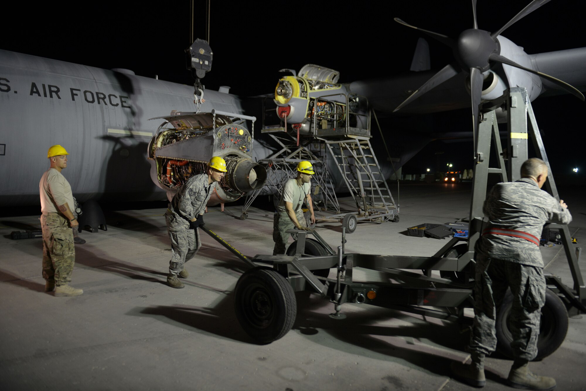 Airmen from the 379th Expeditionary Aircraft Maintenance Squadron, 746th Expeditionary Aircraft Maintenance Unit propulsion flight, position an engine stand into place during an engine swap at the 379th Air Expeditionary Wing, Southwest Asia, Dec. 11, 2013. The engine was swapped out in 12 hours and the aircraft was ready to fly on schedule. (U.S. Air Force photo/Master Sgt. David Miller)
