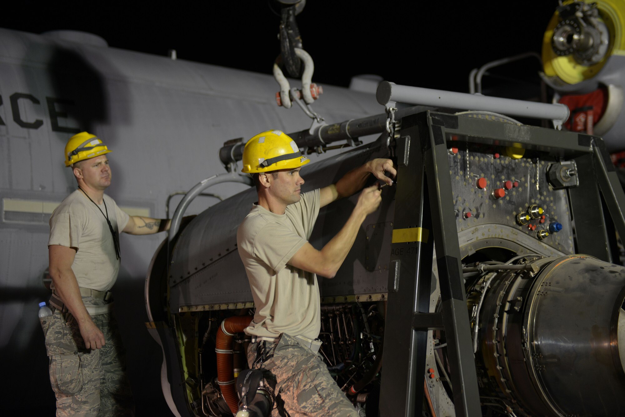 Senior Airman Michael Johnson (right) and Senior Airman Phillip Swensen, 379th Expeditionary Aircraft Maintenance Squadron, 746th Expeditionary Aircraft Maintenance Unit propulsion journeymen, align a C-130 engine on to an engine stand after an engine change at the 379th Air Expeditionary Wing, Southwest Asia, Dec. 11, 2013. The 557th Expeditionary Red Horse Squadron provided short notice support for the engine swap by supplying the crane and personnel to hoist the engine out and install the new engine. The combined efforts contributed to the engine being changed out in 12 hours and the aircraft ready to fly on schedule. Johnson is deployed from Keesler Air Force Base, Miss., and a Mobile, Ala., native. (U.S. Air Force photo/Master Sgt. David Miller)