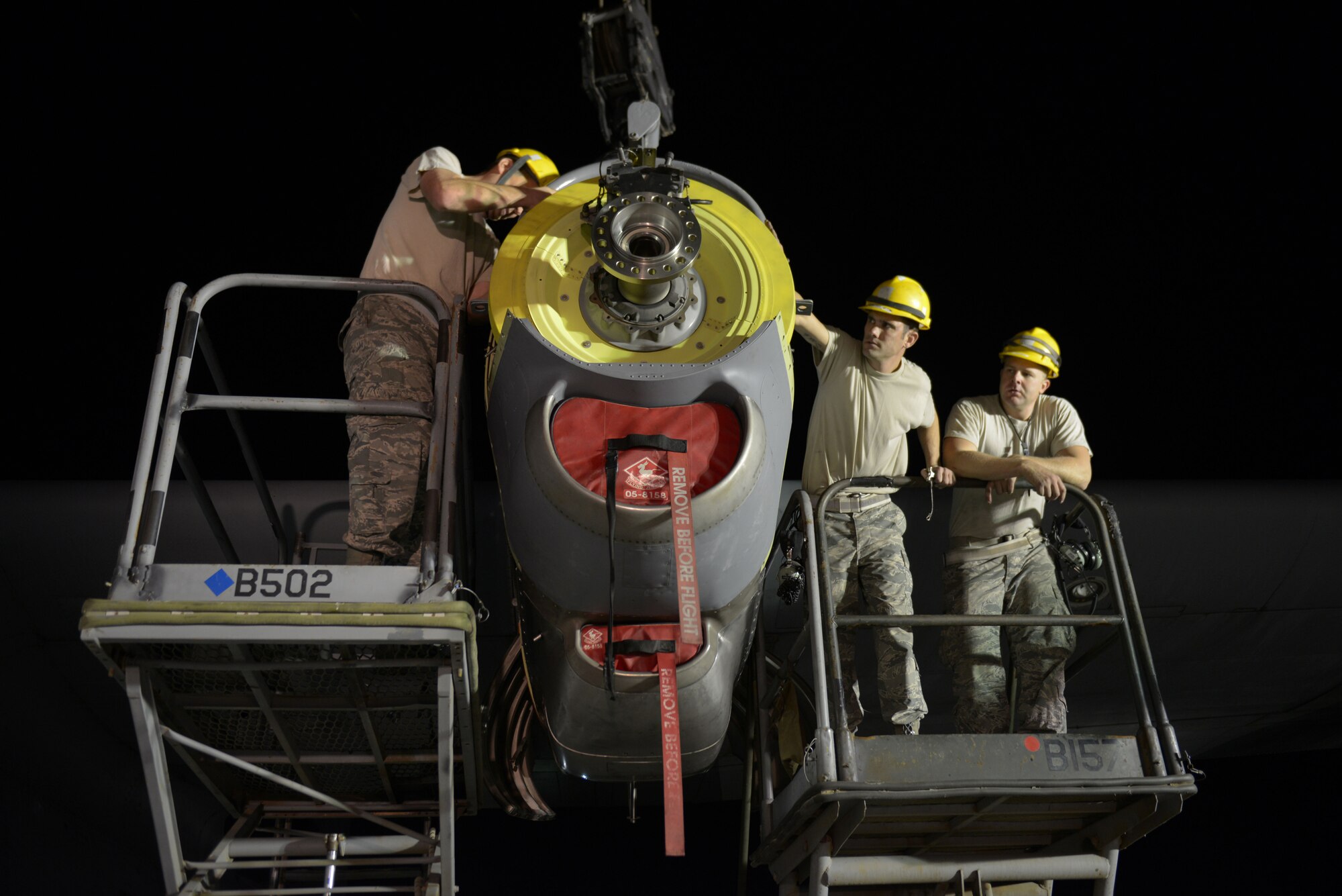 Airmen from the 379th Expeditionary Aircraft Maintenance Squadron, 746th Expeditionary Aircraft Maintenance Unit propulsion flight, install an engine into a C-130J at the 379th Air Expeditionary Wing, Southwest Asia, Dec. 11, 2013. The 557th Expeditionary Red Horse Squadron provided short notice support for the engine swap by supplying the crane and personnel to hoist the engine out and install the new engine. The combined efforts contributed to the engine being swapped in 12 hours and the aircraft ready to fly on schedule. (U.S. Air Force photo/Master Sgt. David Miller)