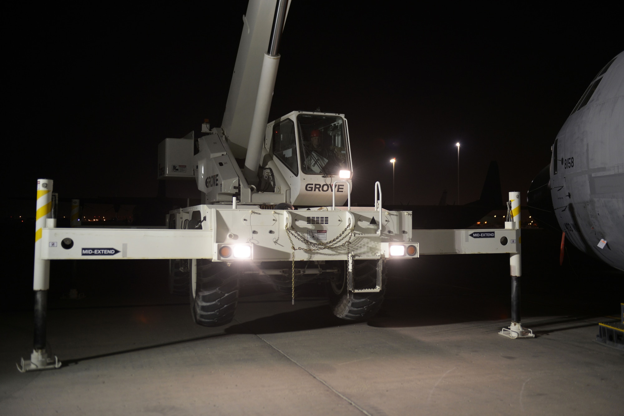 Staff Sgt. Daniel Fox, 557th Expeditionary Red Horse Squadron heavy equipment operator, controls a crane during an engine swap by members of the 379th Expeditionary Aircraft Maintenance Squadron, 746th Expeditionary Aircraft Maintenance Unit at the 379th Air Expeditionary Wing, Southwest Asia, Dec. 11, 2013. The 557th Expeditionary Red Horse Squadron provided short notice support for the engine swap by supplying the crane and personnel to hoist the engine out and install the new engine. The combined efforts contributed to the engine being swapped in 12 hours and the aircraft ready to fly on schedule. Fox is deployed from Nellis Air Force Base, Nev., and a Logansport, Ind., native. (U.S. Air Force photo/Master Sgt. David Miller)