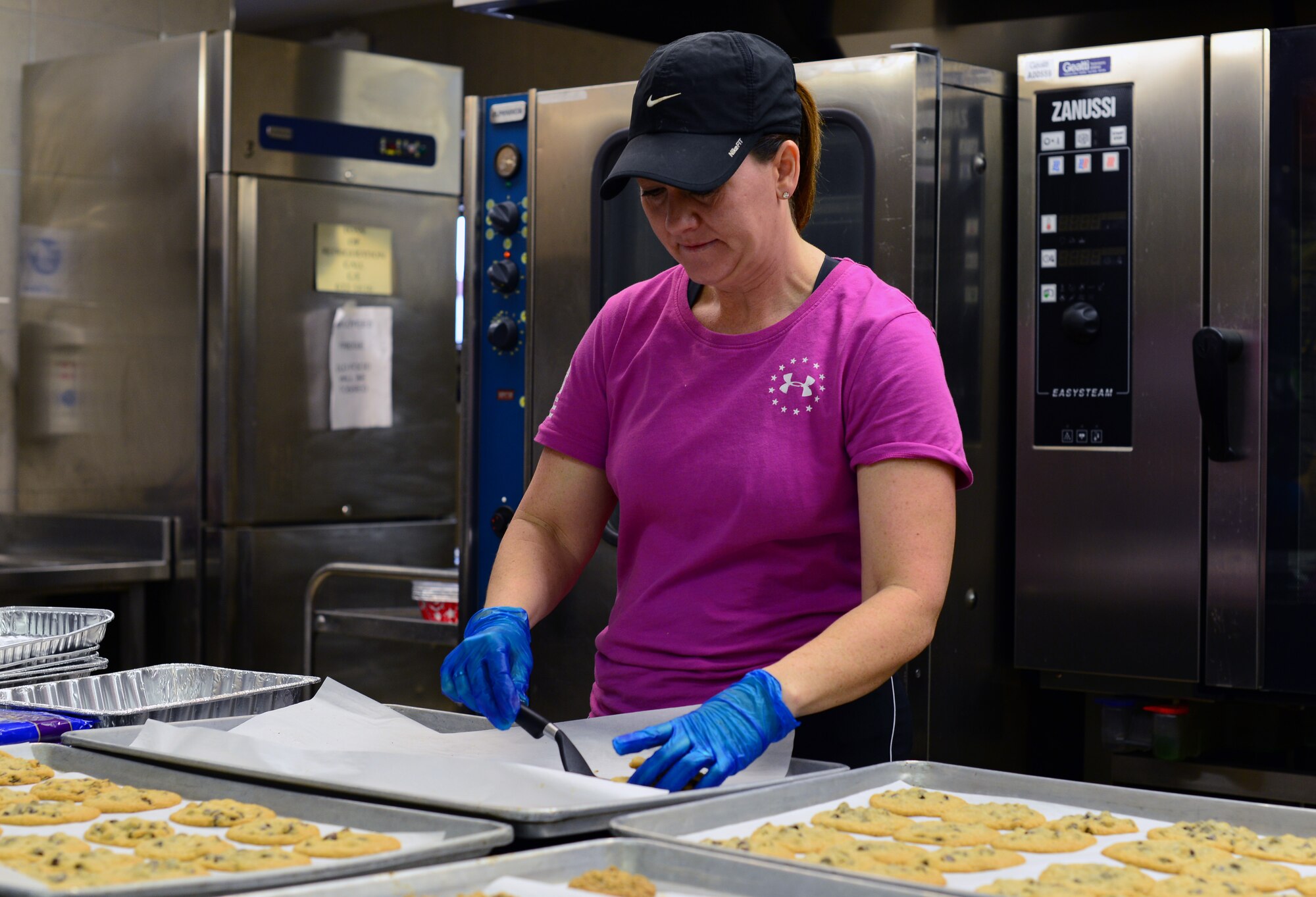 Melissa Raethka, Aviano Officers and Civilian Spouses’ Club volunteer, prepares freshly baked cookies for distribution during the annual Aviano Cookie Drive Dec. 9, 2013, at Aviano Air Base, Italy. Along with the cookies, volunteers attached a handmade Christmas card collected by the Red Cross and Aviano Elementary School to every bag.  (U.S. Air Force photo/Senior Airman Michael Battles)