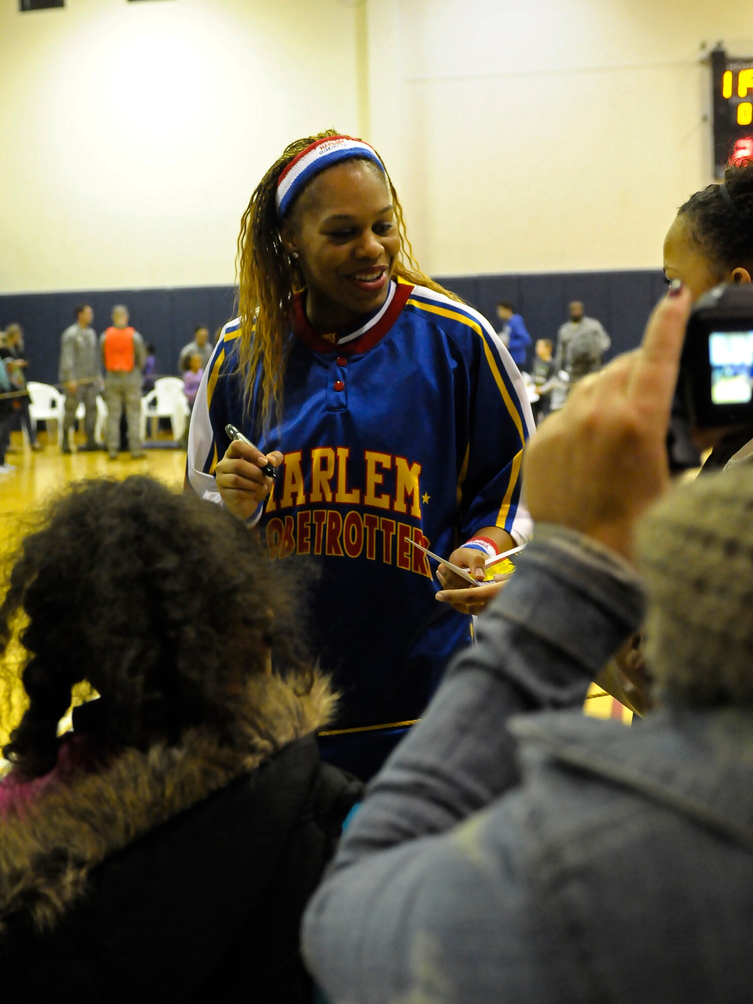 Sweet J., Harlem Globetrotters guard, signs autographs for fans during the 12th Annual Harlem Globetrotters Holiday Tour Dec. 10, 2013, at Aviano Air Base, Italy. Sponsored by Navy and Armed Forces Entertainment, with support from the 31st Force Support Squadron, the Globetrotters hosted two shows that entertained more than 1,000 Team Aviano and Italian community members. (U.S. Air Force photo/Airman 1st Class Deana Heitzman)