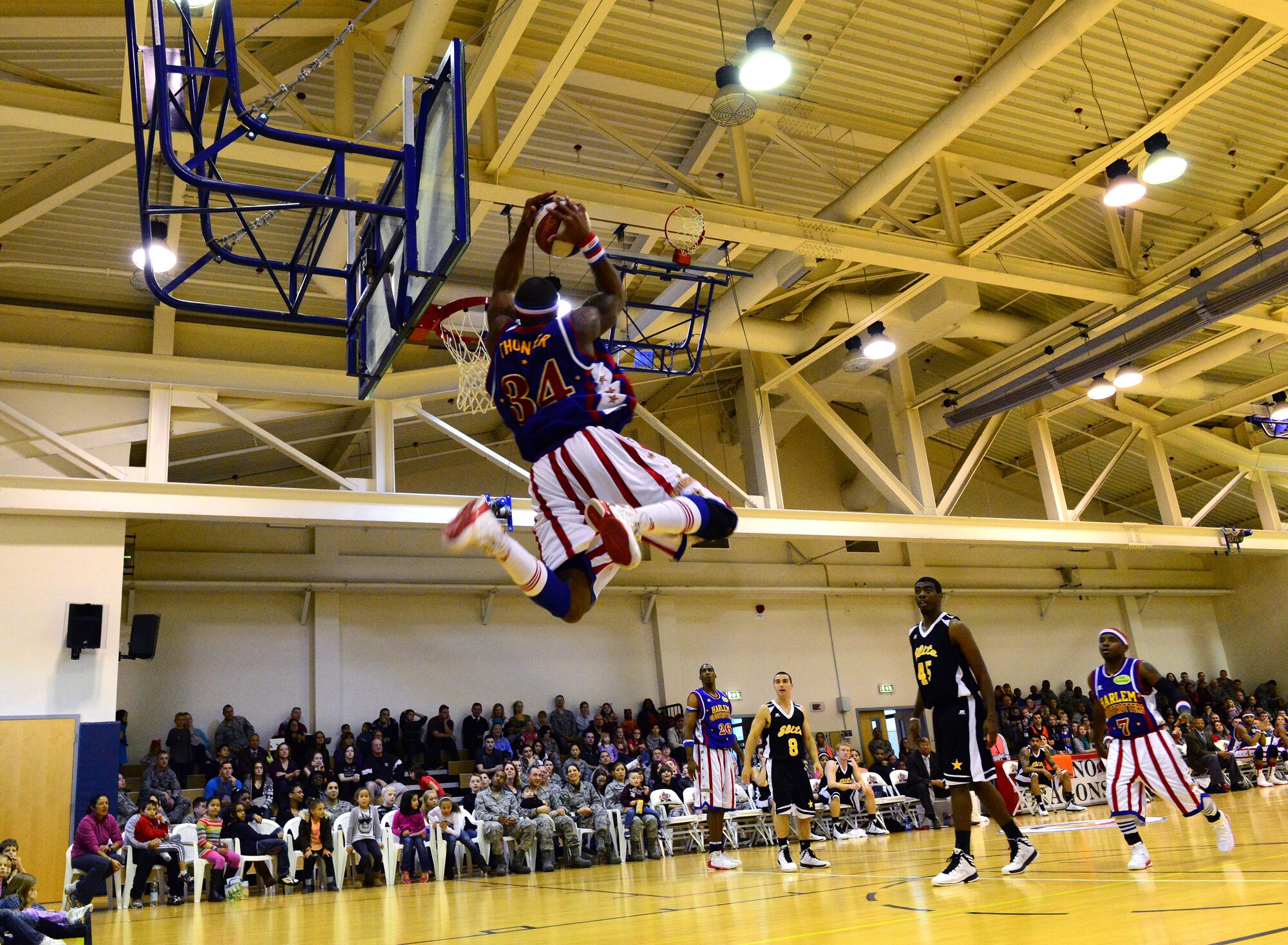 Thunder, Harlem Globetrotters forward, slam dunks during the 12th Annual Harlem Globetrotters Holiday Tour Dec. 10, 2013, at Aviano Air Base, Italy. The Harlem Globetrotters defeated the International Elite team with a final score of 119-89. (U.S. Air Force photo/Senior Airman Michael Battles)