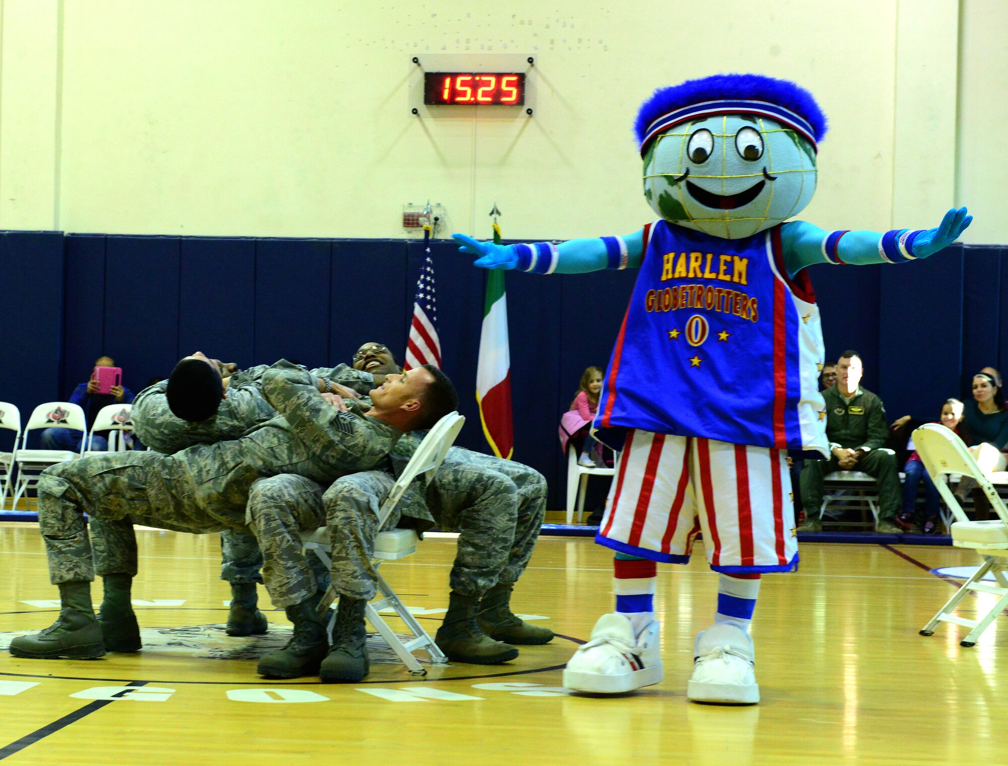 The Harlem Globetrotters mascot, Globie, uses four service members to build a table during his pre-game show part of the 12th Annual Harlem Globetrotters Holiday Tour Dec. 10, 2013, at Aviano Air Base, Italy. (U.S. Air Force photo/Senior Airman Michael Battles)