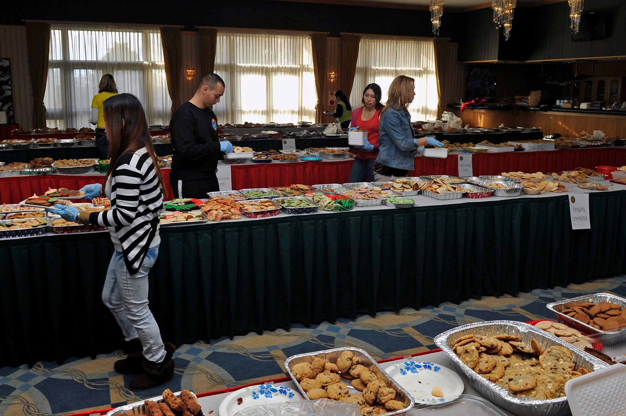 Cookie Caper volunteers round tables and pick out different types of cookies for unaccompanied service members at Misawa Air Base, Japan, Dec. 11, 2013. The event was sponsored by the Misawa Officers’ and Enlisted Spouses’ Clubs and brought in more than 20,000 cookies for the base’s single and unaccompanied service members. (U.S. Air Force photo by Airman 1st Class Zachary Kee)