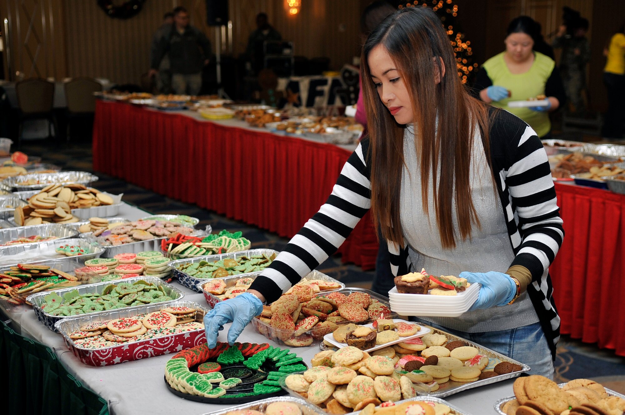 Rosalie Kelker, Cookie Caper volunteer, puts cookies onto a tray during the Cookie Caper at Misawa Air Base, Japan, Dec. 11, 2013. The annual event is put on by the Misawa Officers’ and Enlisted Spouses’ Clubs to provide single and unaccompanied service members who are unable to spend the holiday season with their families a few delicious holiday treats. (U.S. Air Force photo by Airman 1st Class Zachary Kee)
