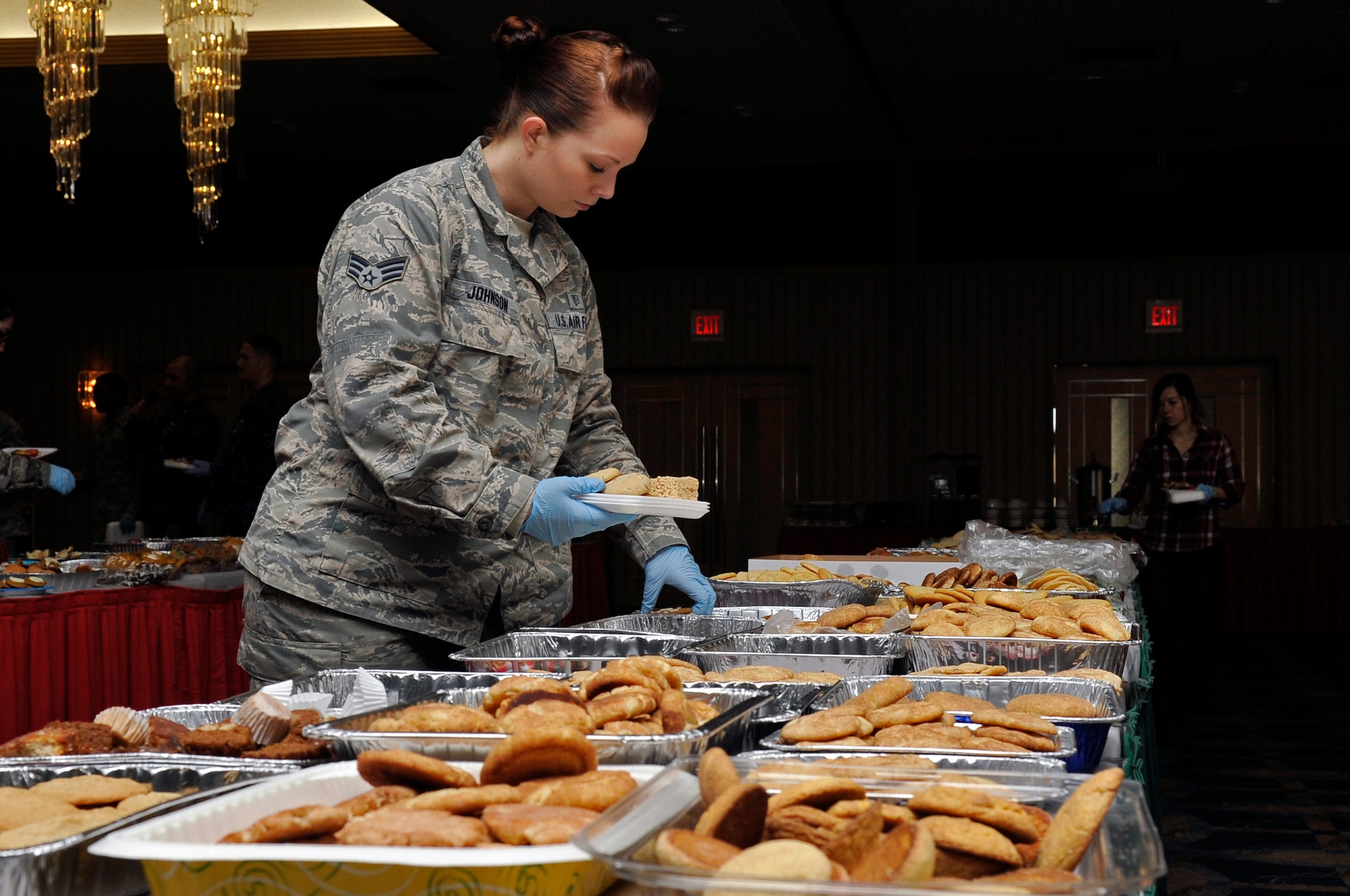 U.S. Air Force Senior Airman Amanda Johnson, 35th Aerospace Medicine Squadron, volunteers to prepare plates full of cookies during the Cookie Caper at Misawa Air Base, Japan, Dec. 11, 2013. Volunteers and members of the Misawa community donated more than 20,000 cookies to the base’s unaccompanied service members who are unable to spend the holidays with their families. (U.S. Air Force photo by Airman 1st Class Zachary Kee)
