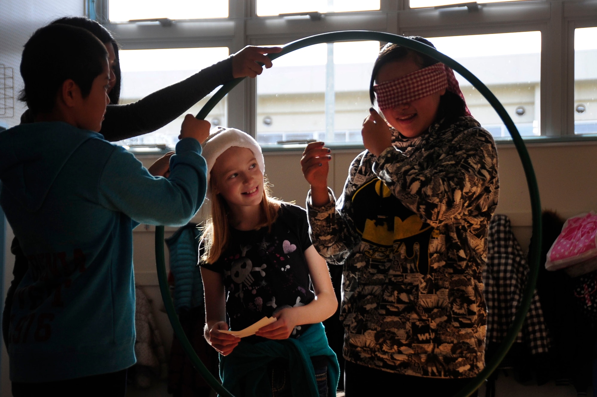 A Sollars Elementary student guides a blindfolded local Japanese student through an obstacle course during the 21st Annual Bilateral Cultural Gift Exchange on Misawa Air Base, Japan, Dec. 7, 2013. The obstacle course allowed the children to build trust and friendships between each other. (U.S. Air Force photo by Tech Sgt. April Quintanilla)